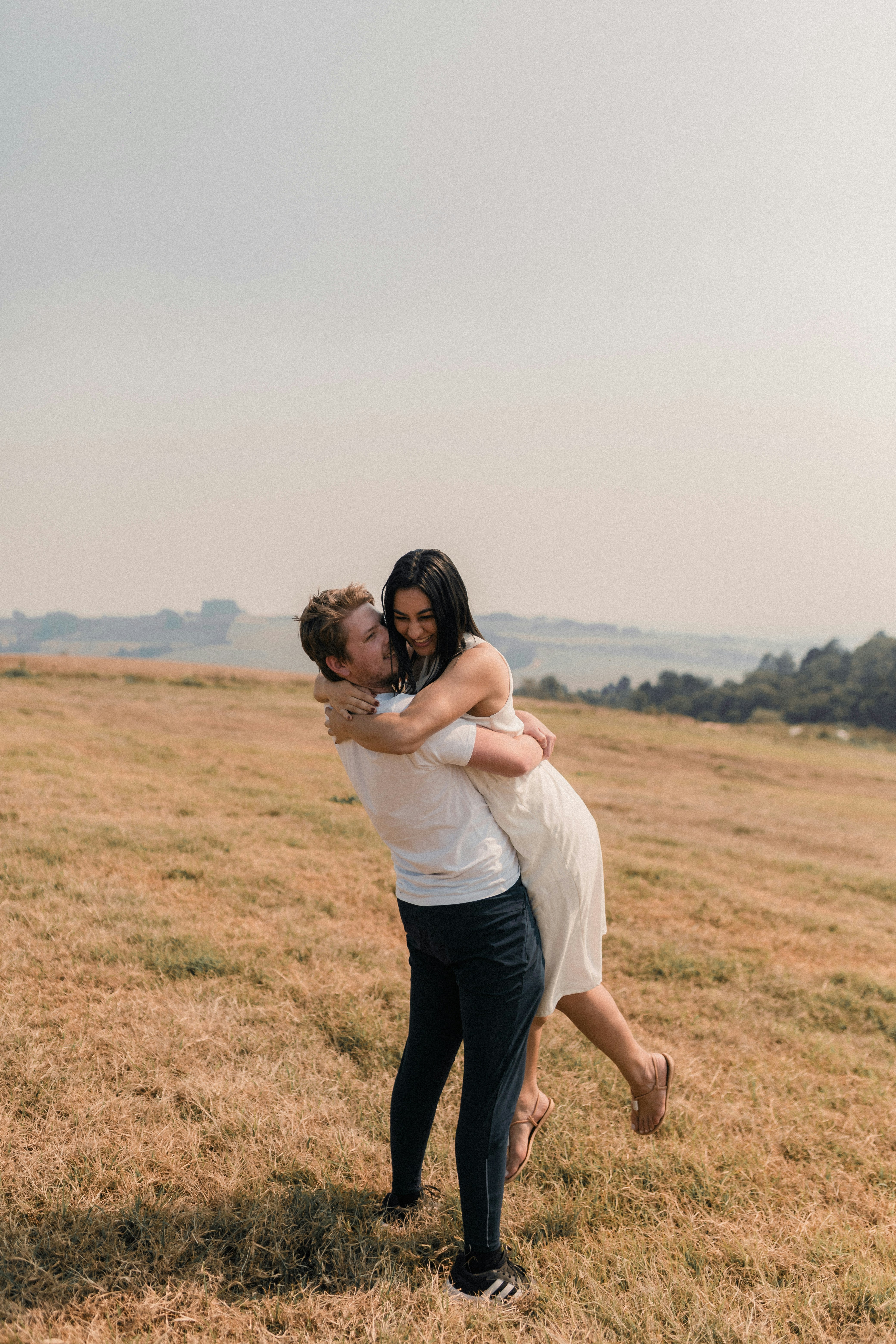 A man holding a woman in a field