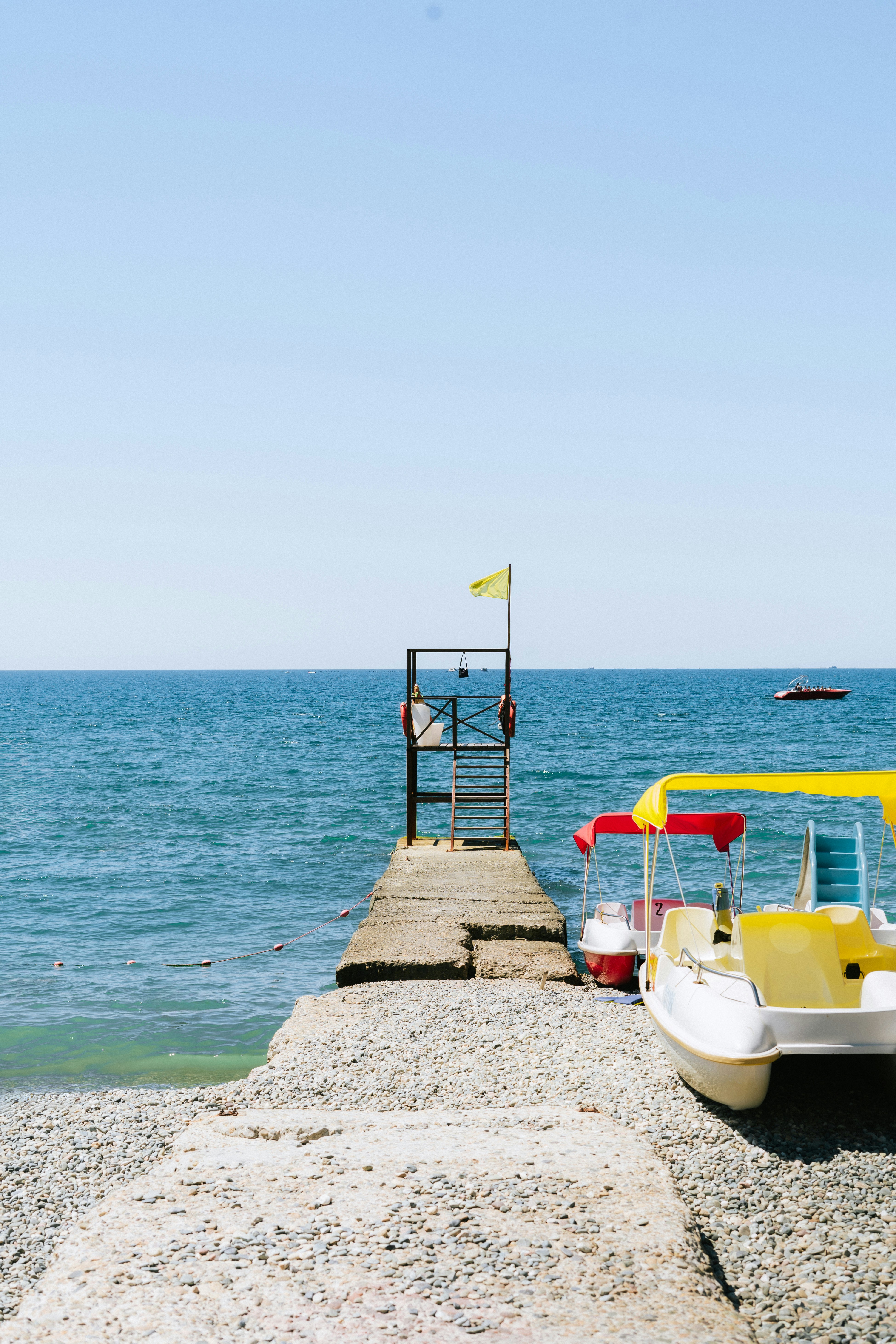 A yellow and white boat sitting on top of a pier