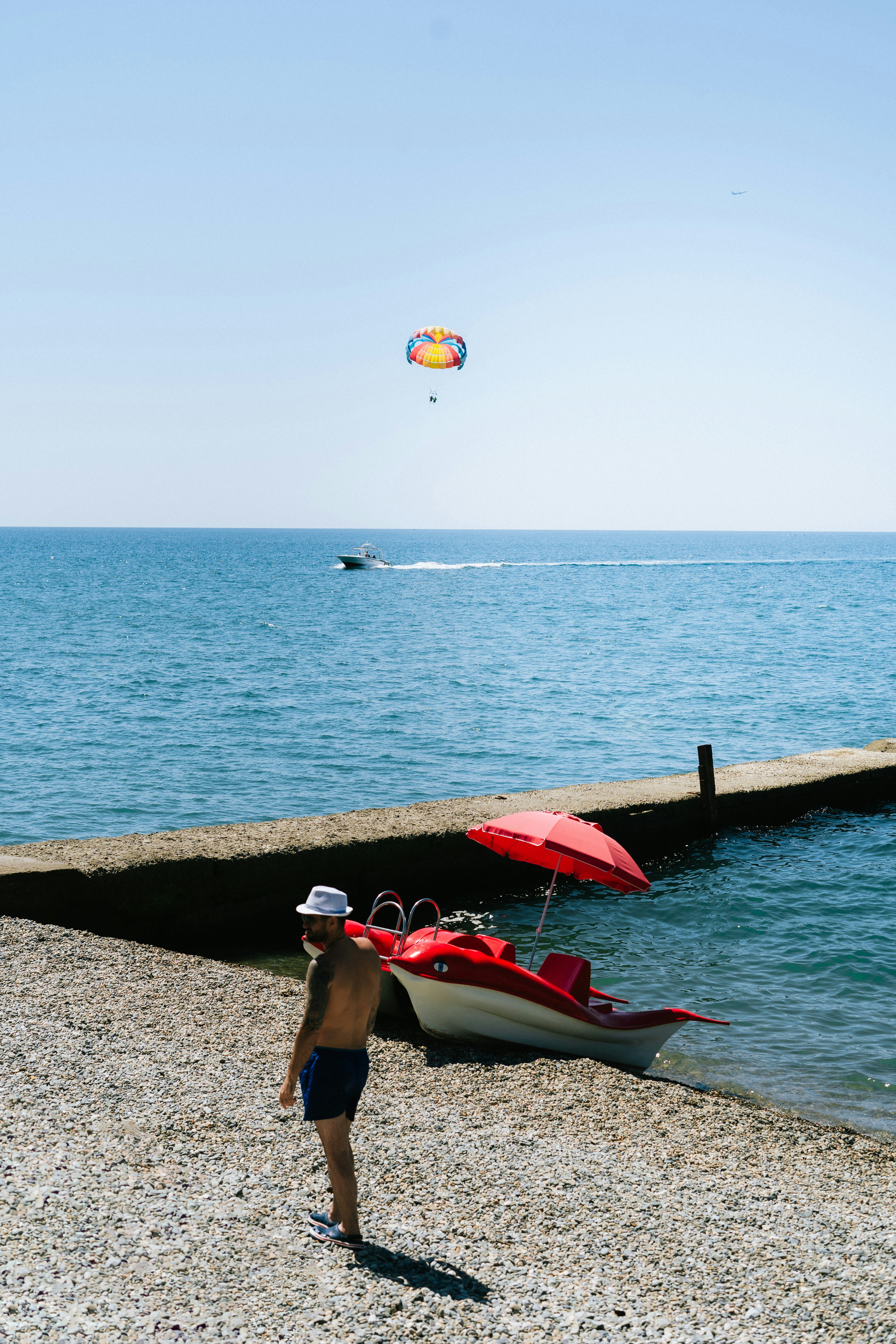 A person walking on a beach next to a boat