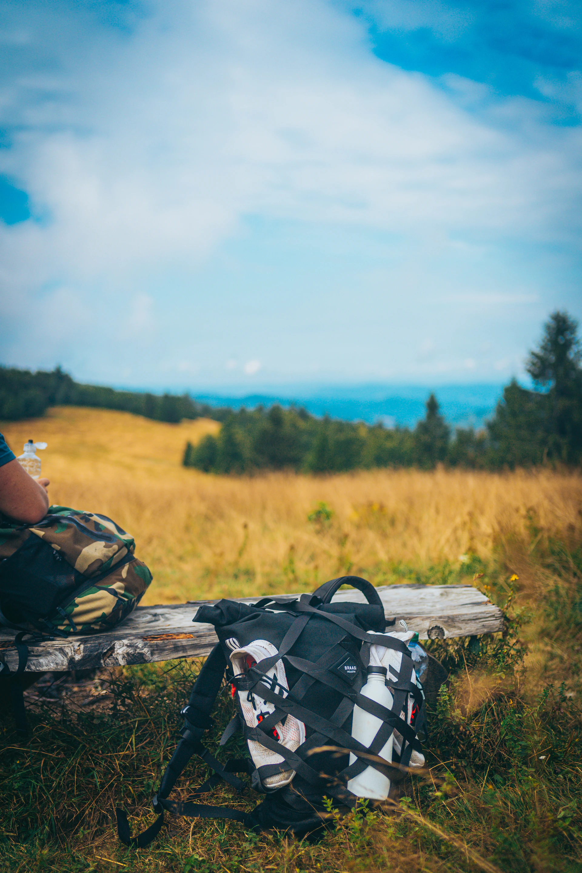 A person sitting on a bench with a backpack