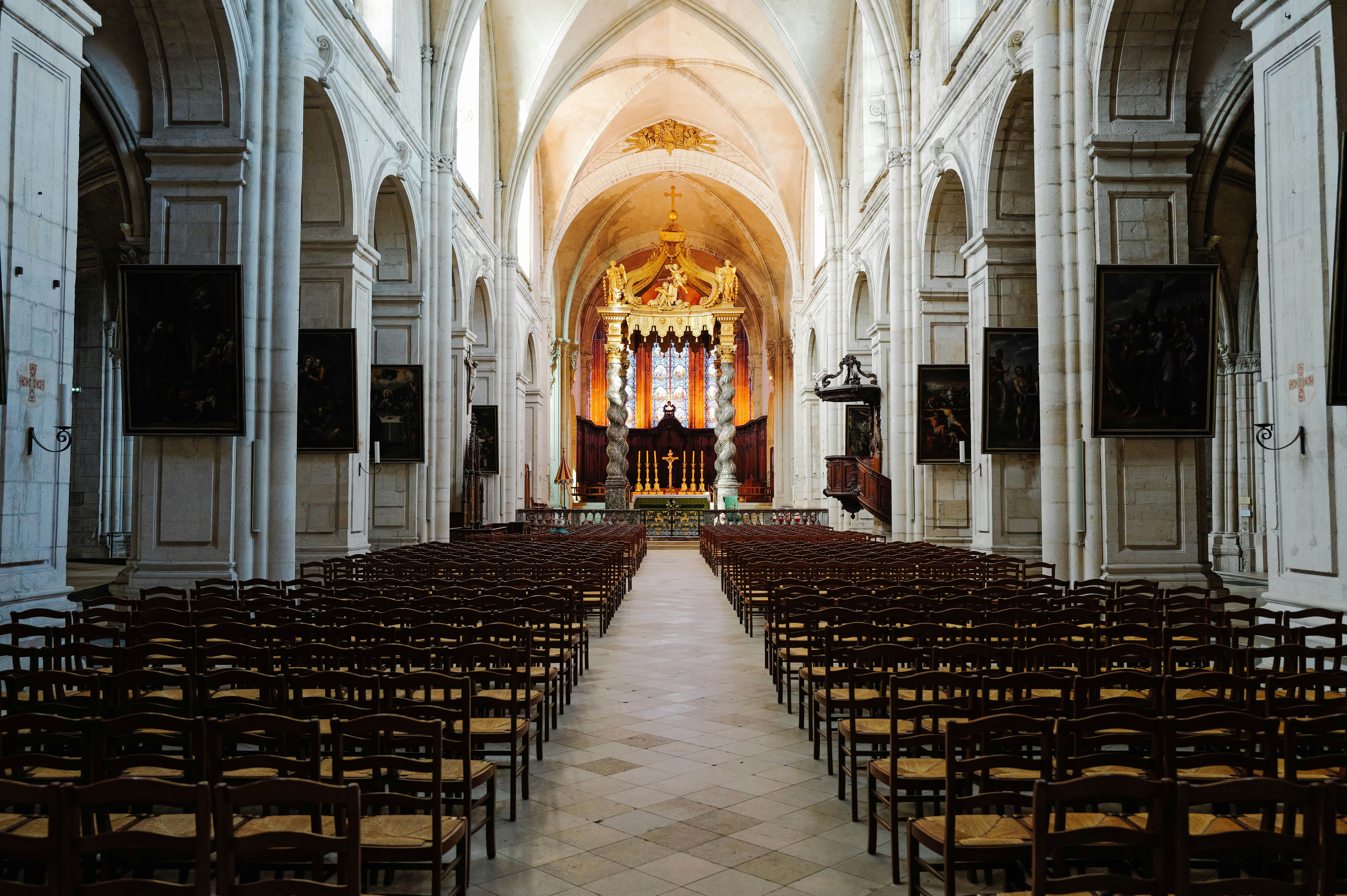 Una iglesia con filas de sillas y un gran altar