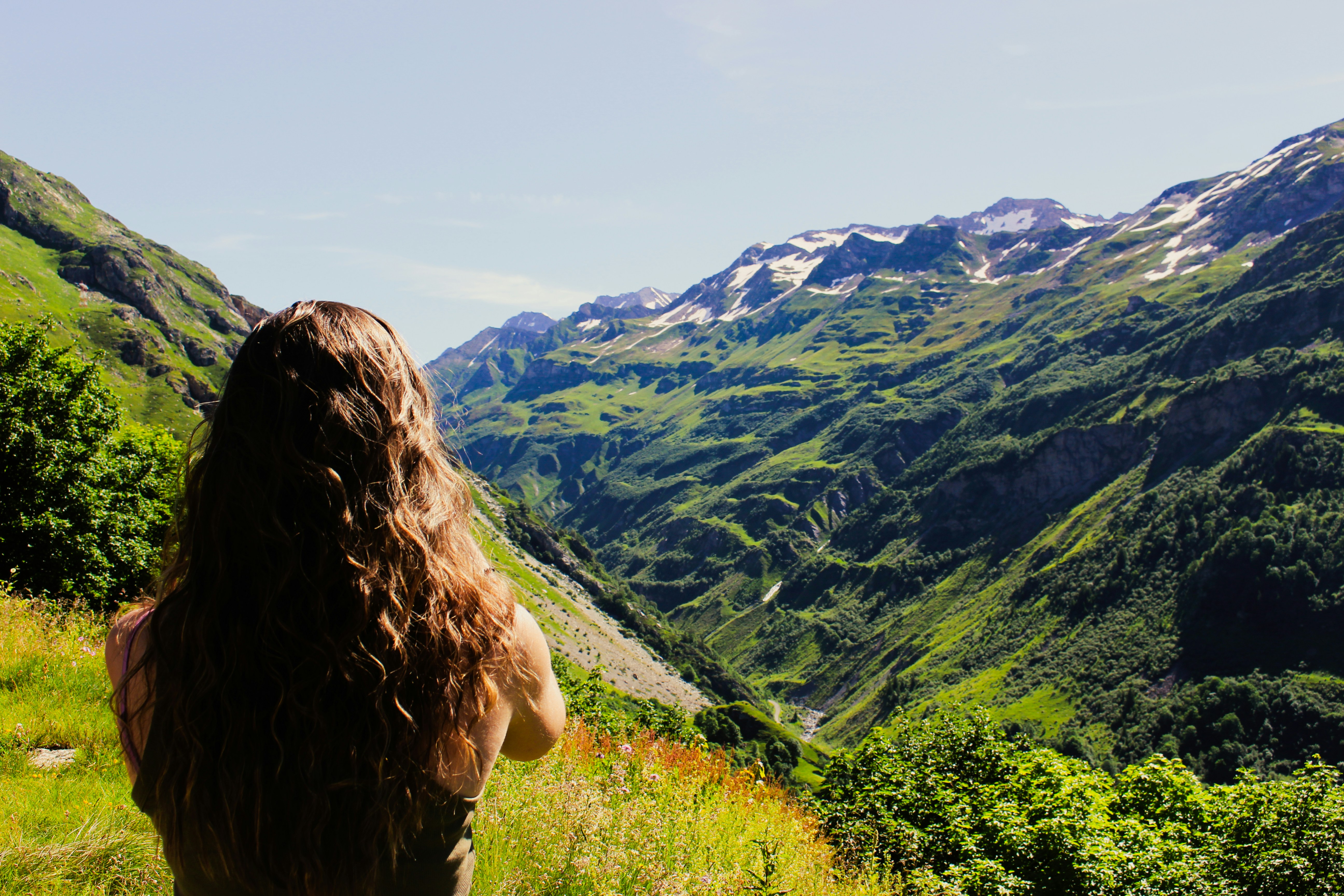 A woman with long hair standing on a hill