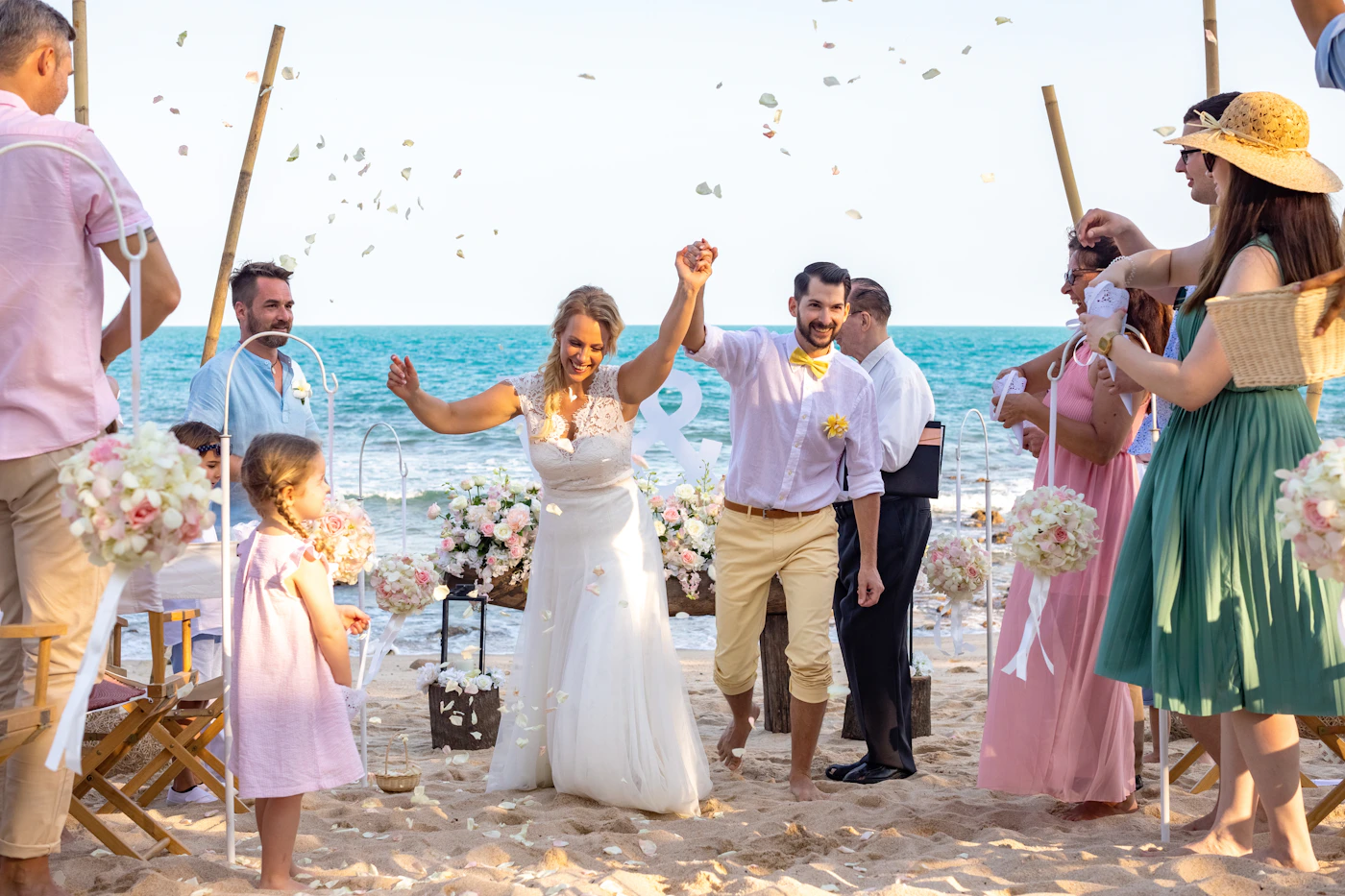Couple during their elopement on a tropical beach with crystal-clear water and volcanic island formations visible in the background