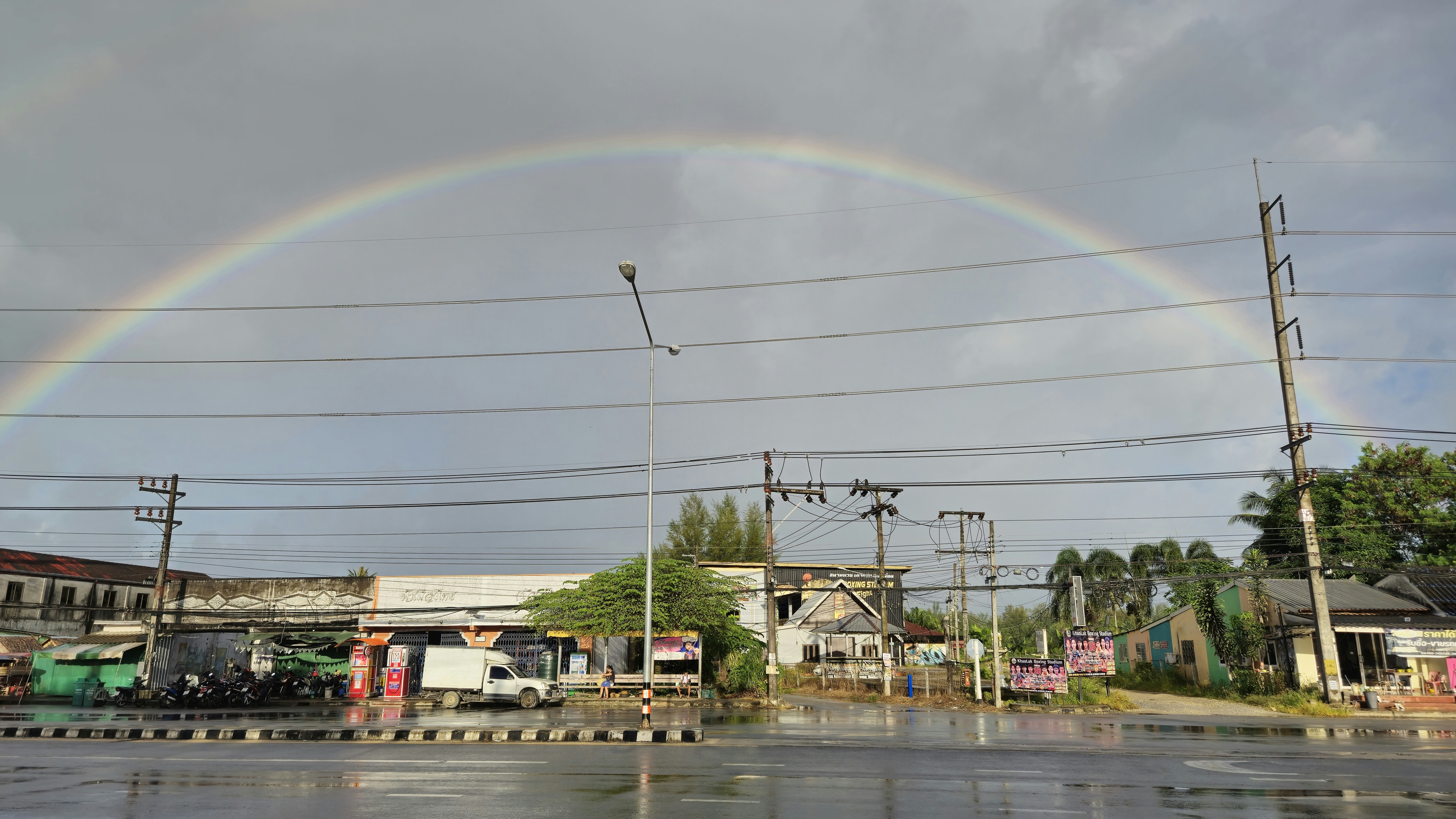 A double rainbow is seen over a city street