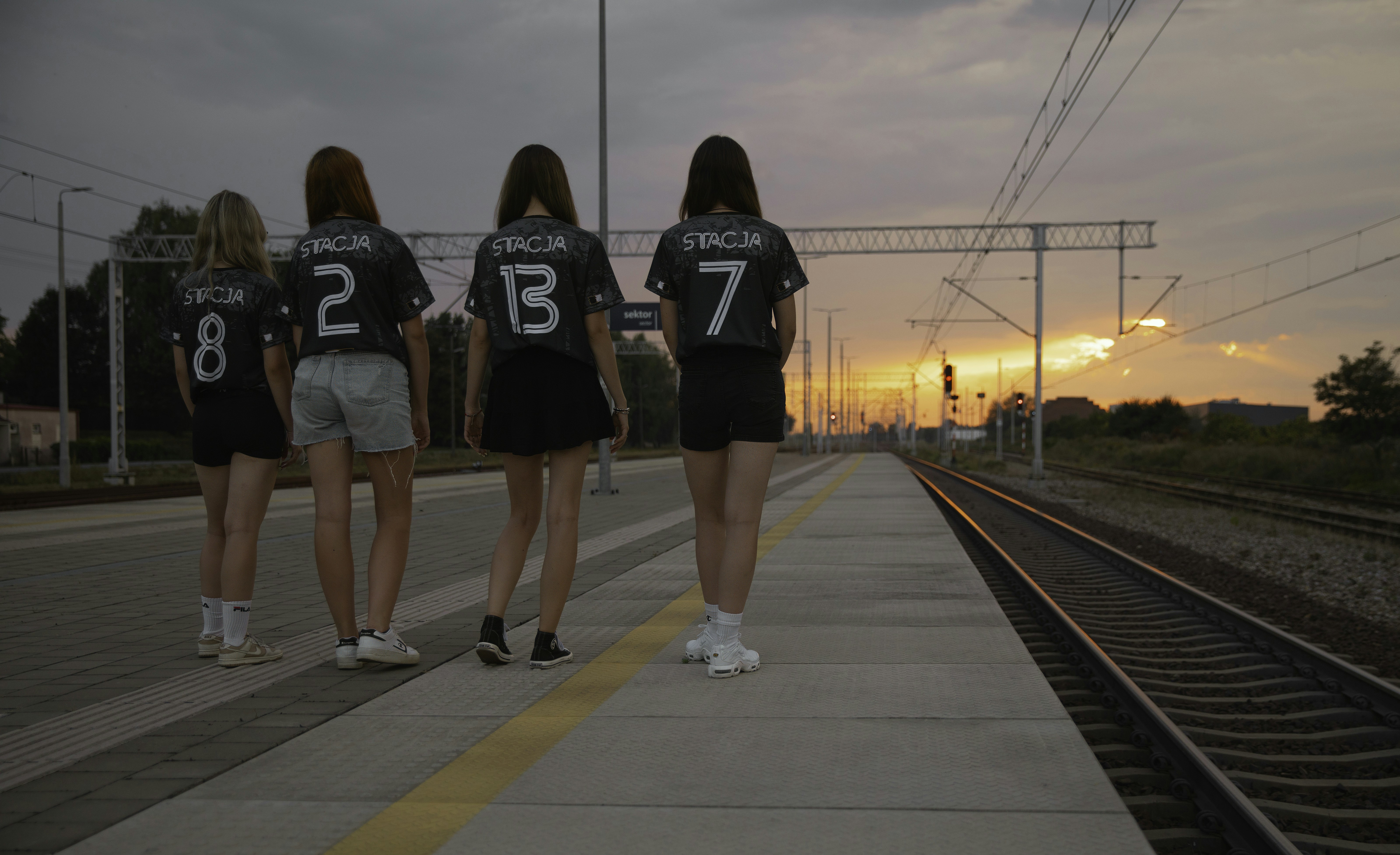 A group of people standing on a train track