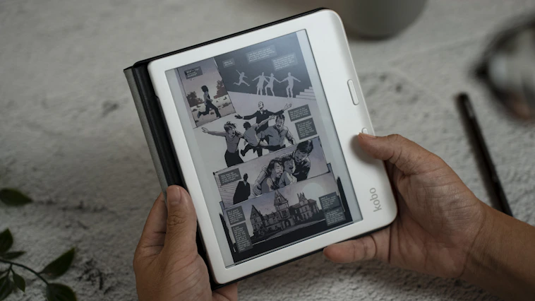 A person holding a tablet with a magazine on it