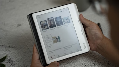A person holding a tablet with a page on it