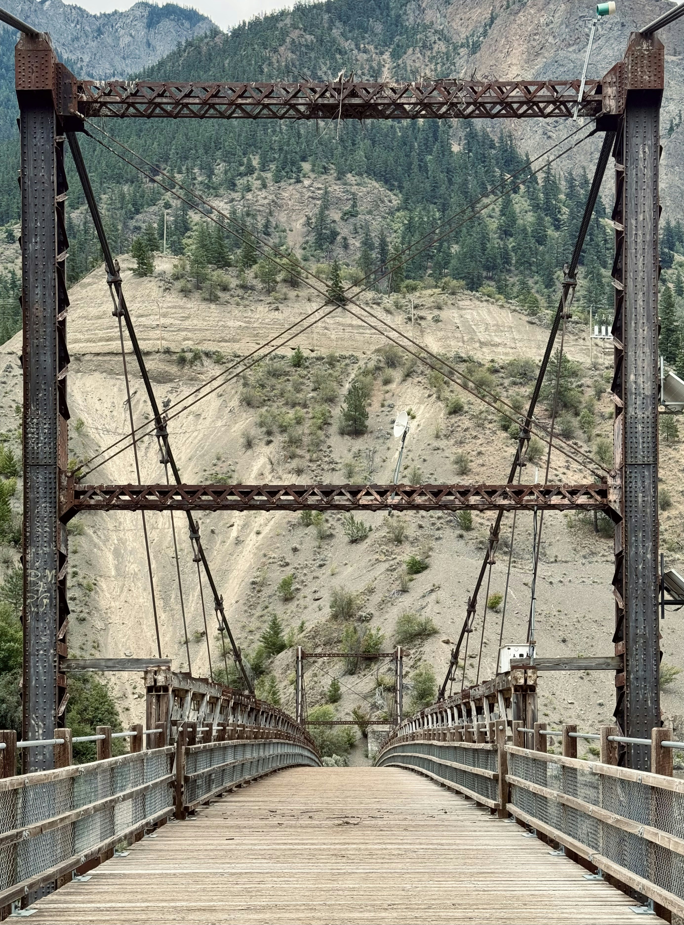 A wooden bridge with mountains in the background