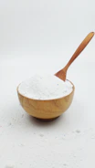 A wooden spoon with white powder in it