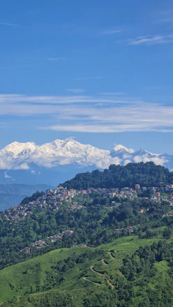 A view of a mountain range with snow capped mountains in the distance