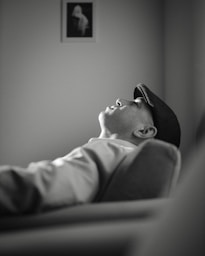 A black and white photo of a man laying on a couch