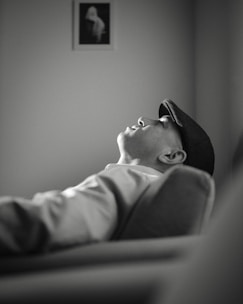 A black and white photo of a man laying on a couch