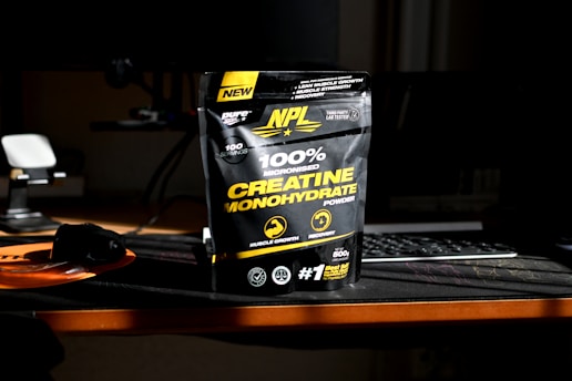 A bag of creatinne on a desk next to a keyboard