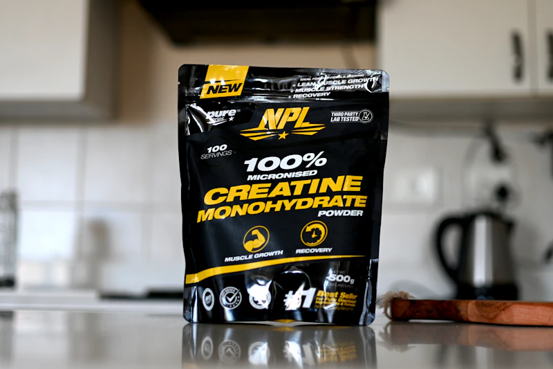 Tub of creatine monohydrate powder with a scoop