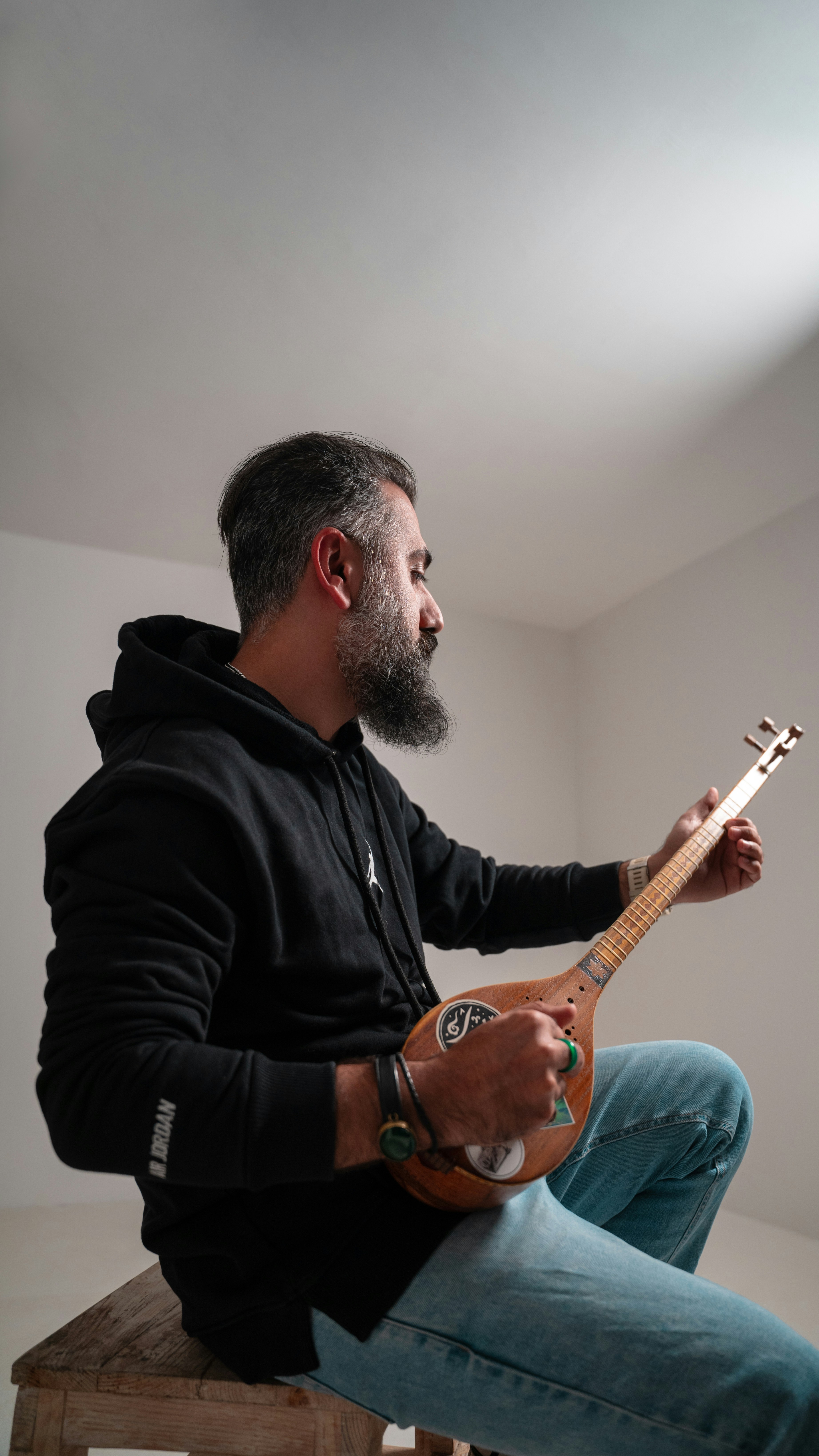 Ein Mann, der auf einem Hocker sitzt und Gitarre spielt