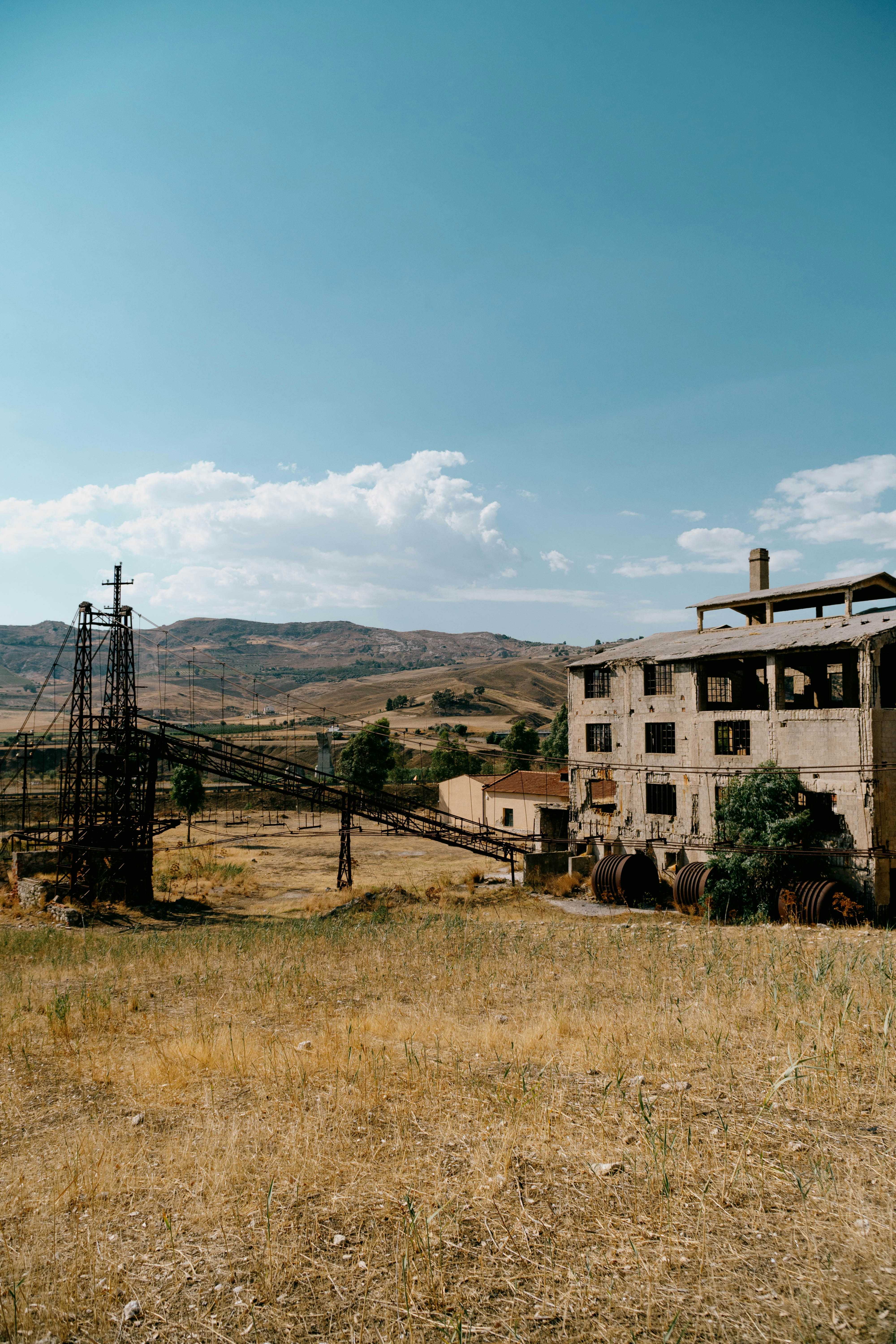 An abandoned building in a field with power lines in the background ...