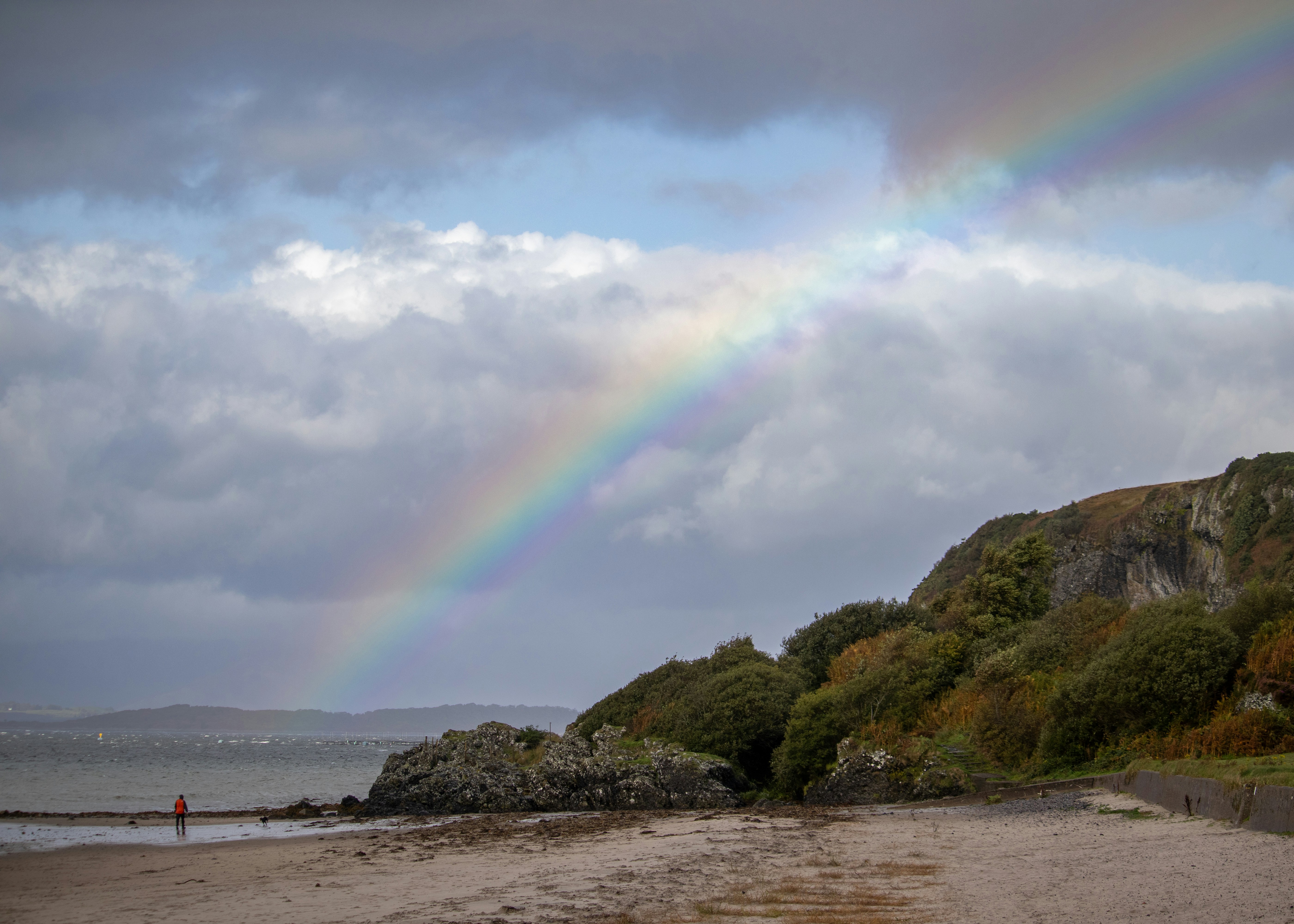 Un arco iris en el cielo sobre una playa