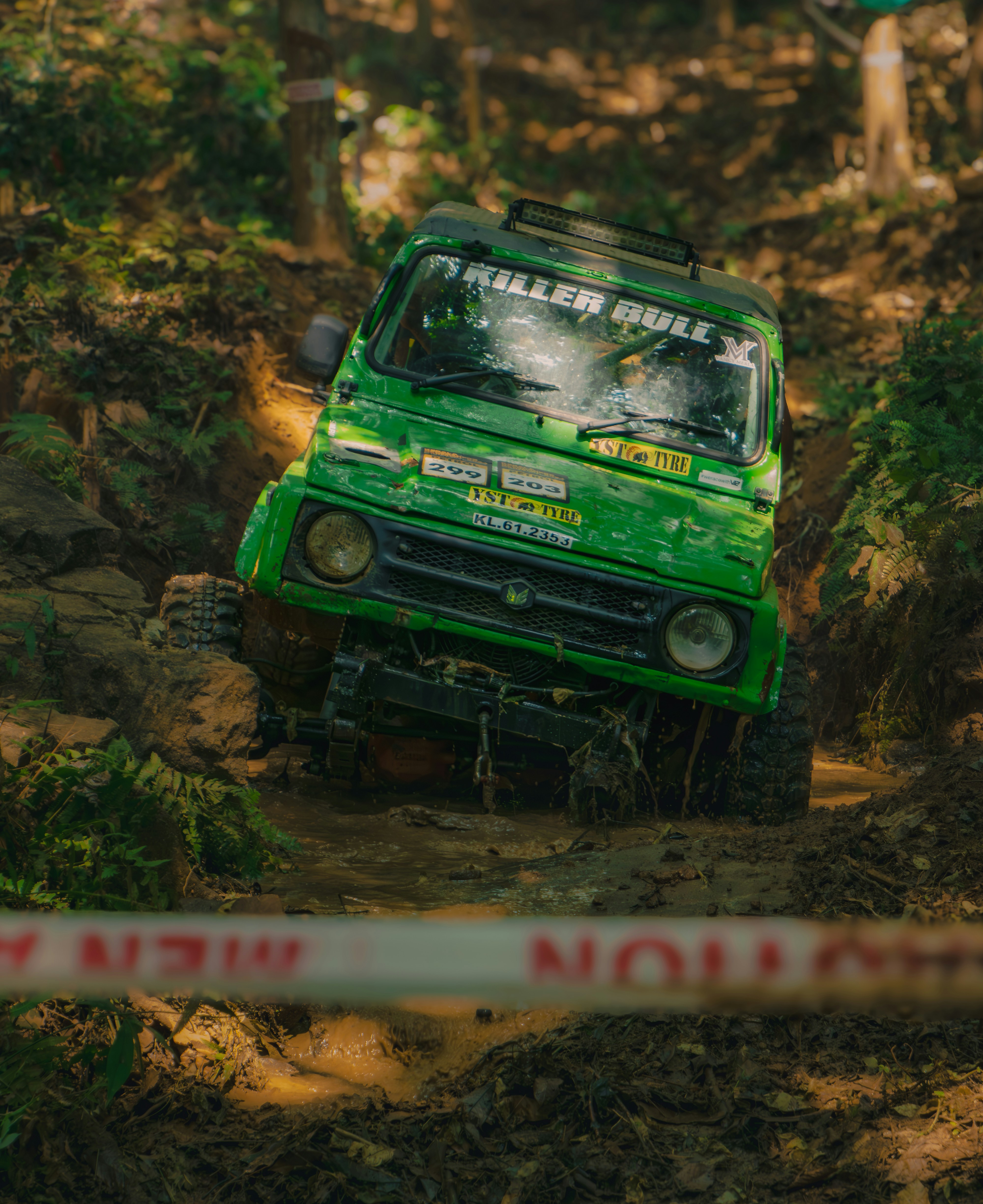 A green truck driving through a forest filled with trees photo – Free ...