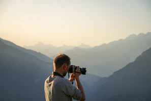 A man taking a picture of a mountain range