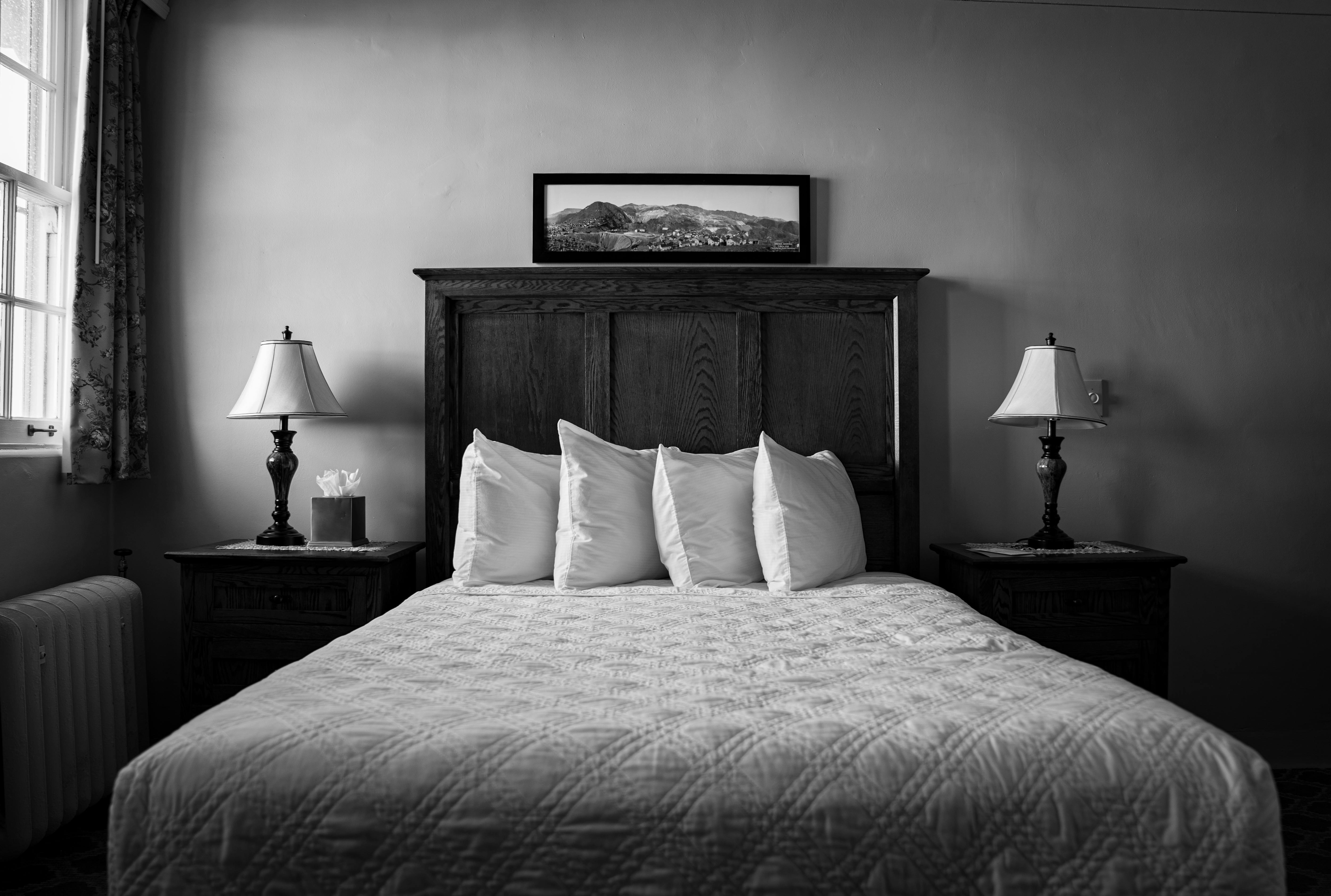 A black and white photo of a bed in a bedroom