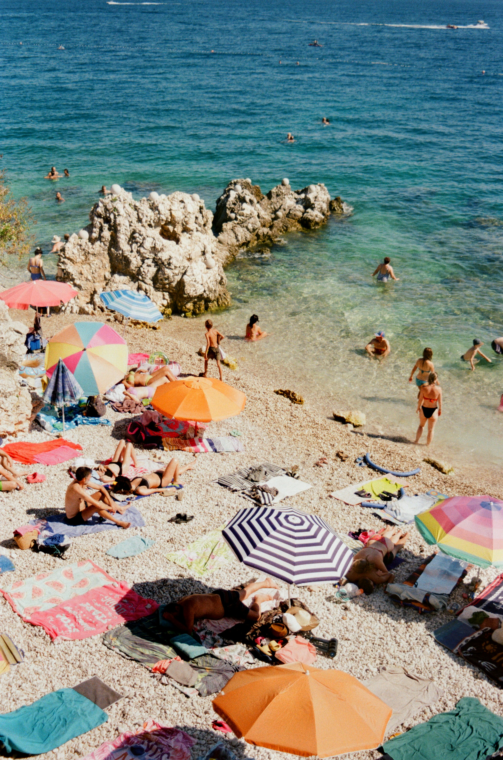 A beach filled with lots of people and umbrellas