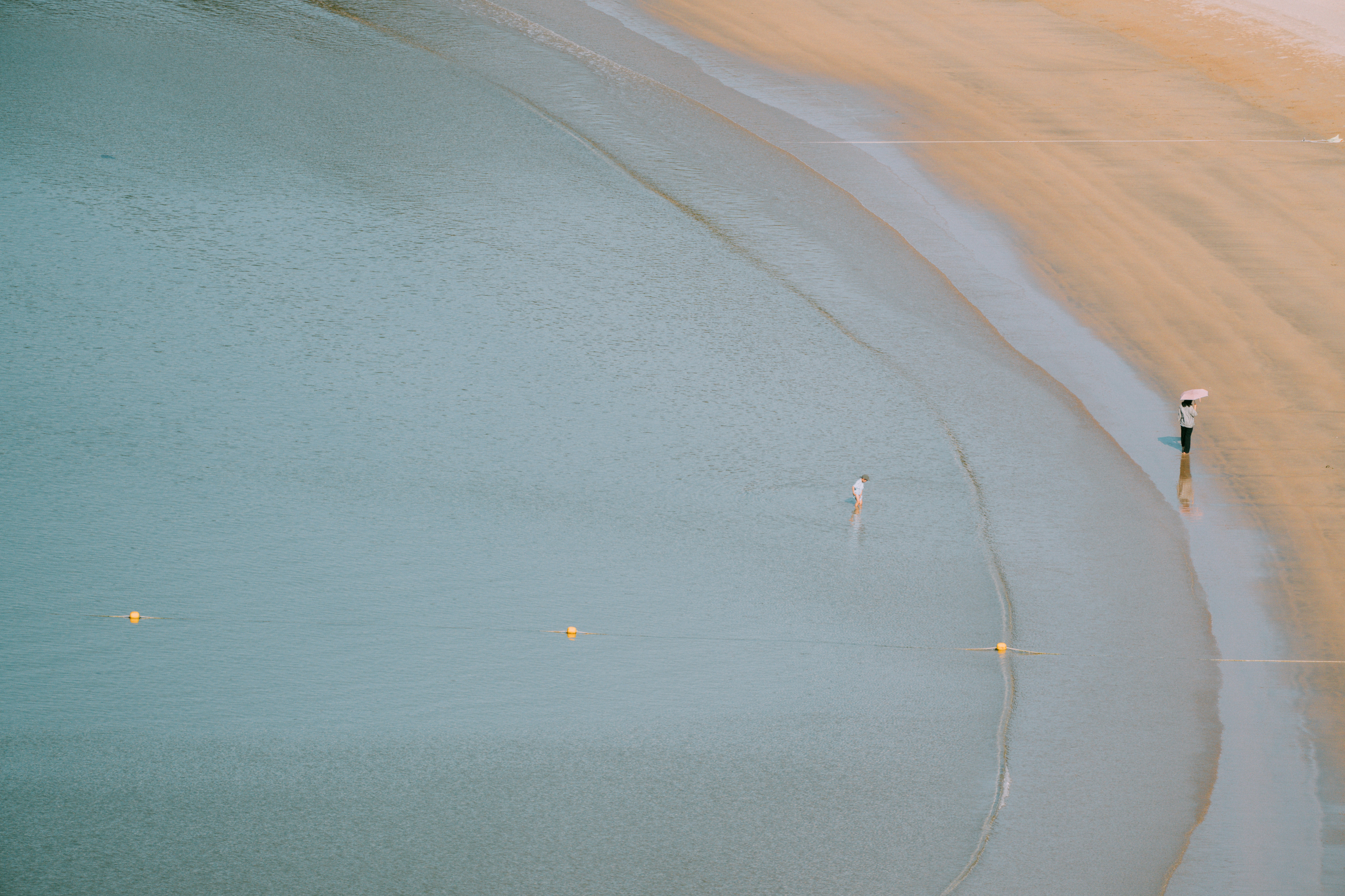 A person walking along a beach next to the ocean