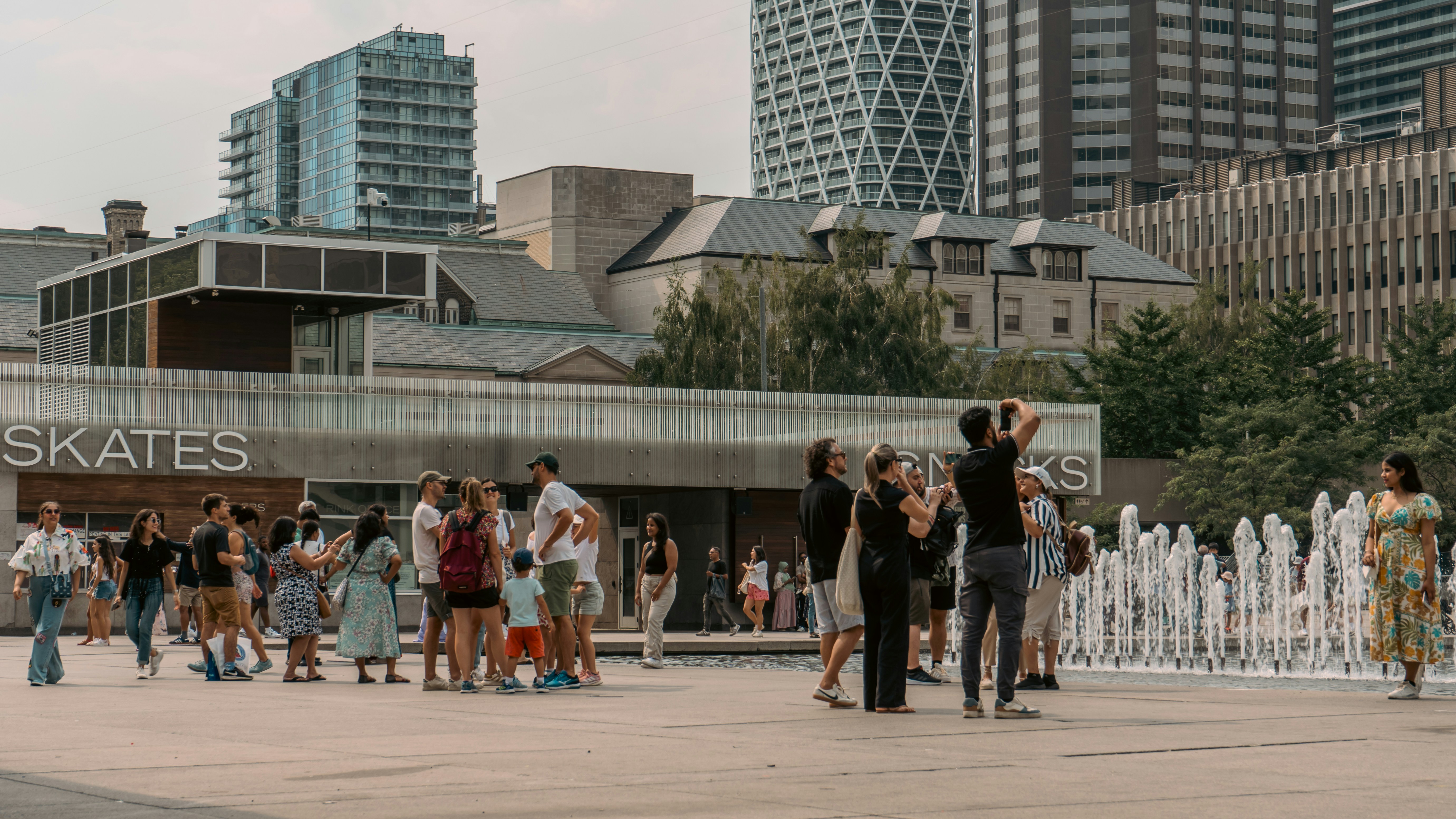 Une foule de personnes rassemblées autour d une fontaine lors d un événement public animé au Canada.