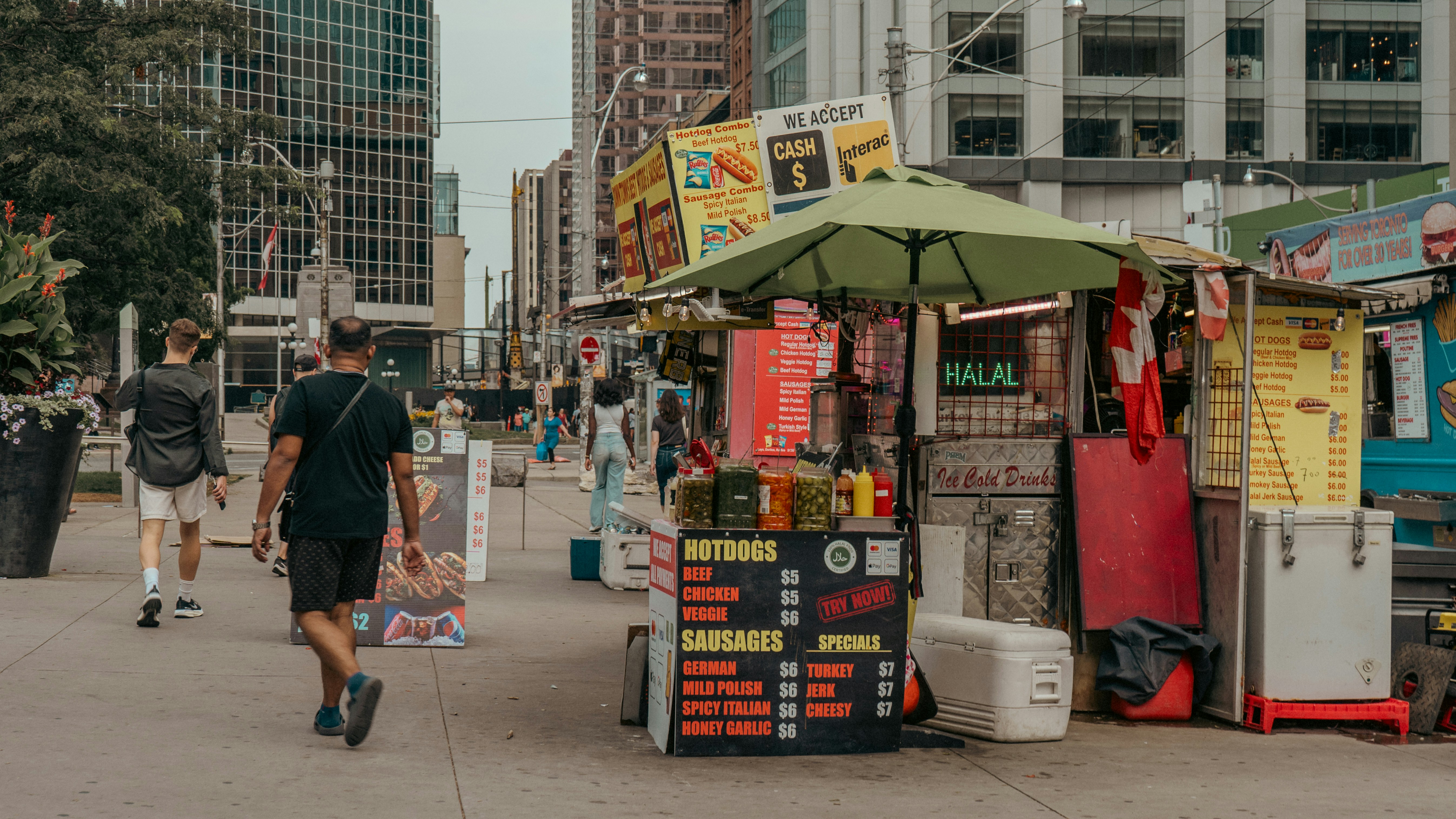 A man walking down a street next to a vending stand