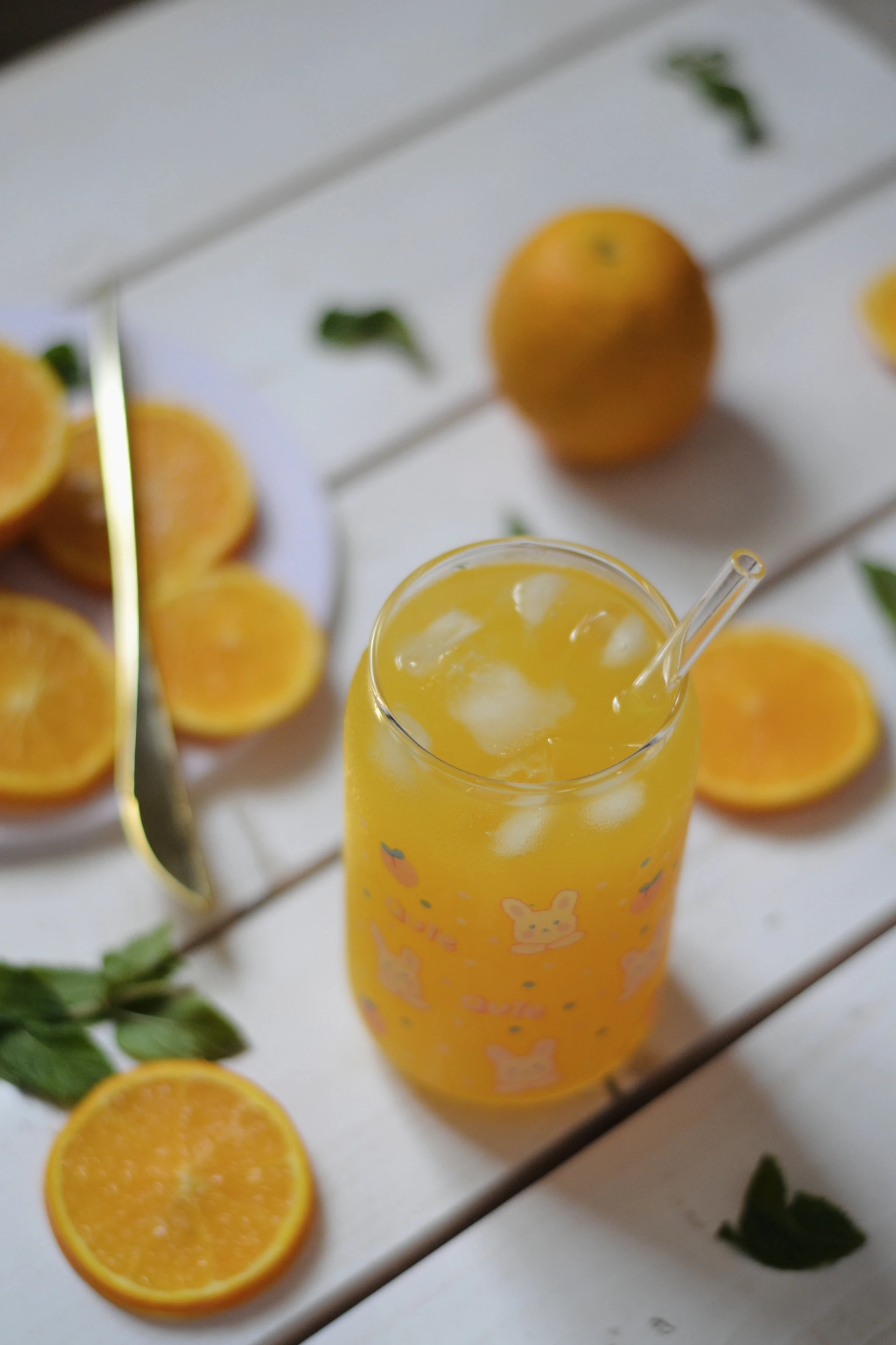 A glass of orange juice with a straw