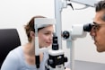 A man and a woman looking through a microscope