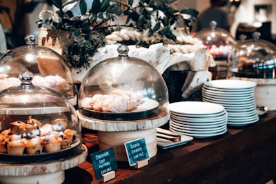 A table topped with lots of food covered in glass domes
