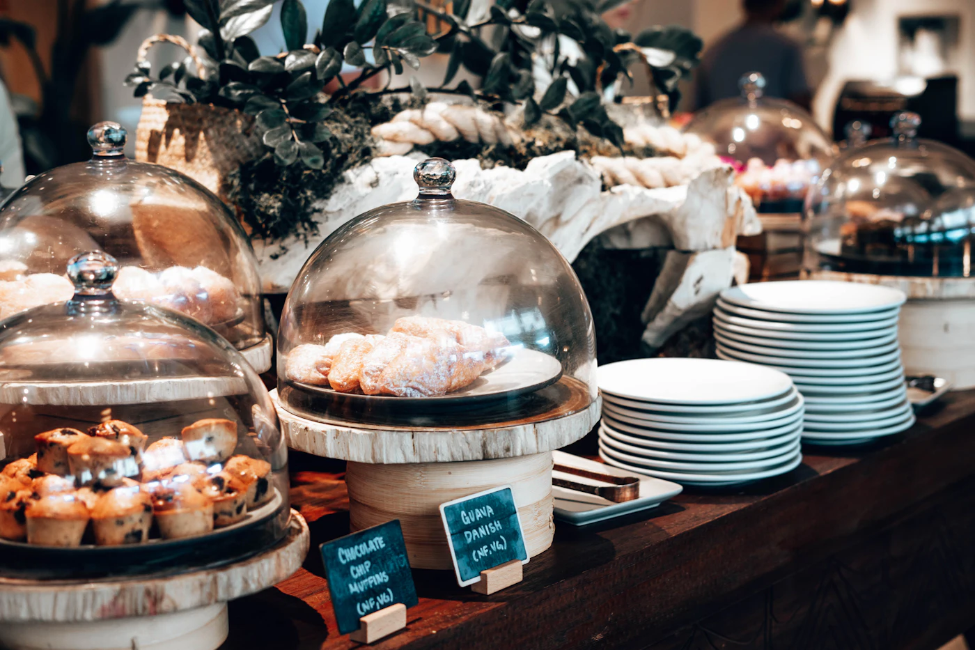 Table de buffet avec pâtisseries présentées sous cloches en verre