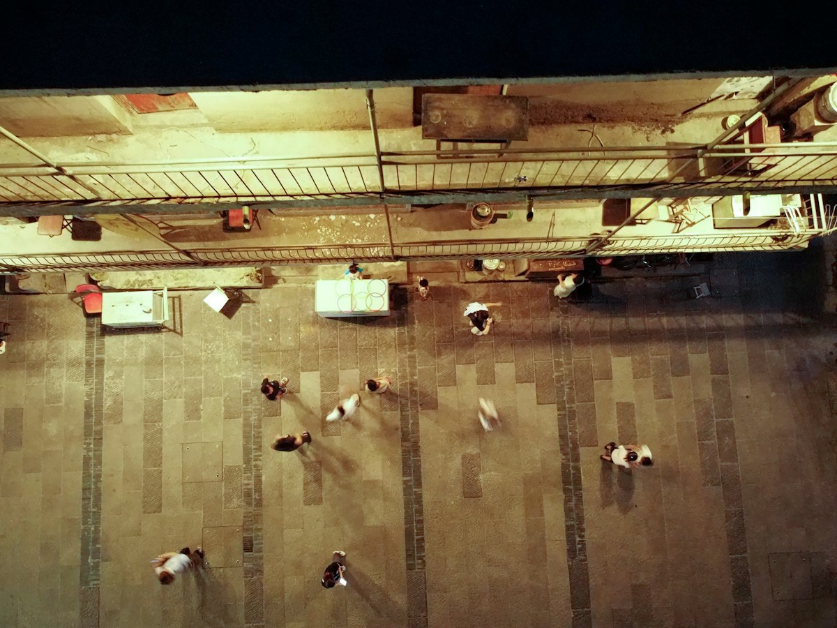 People walking on a dimly lit street at night, unrelated to classroom setup or teaching environment.