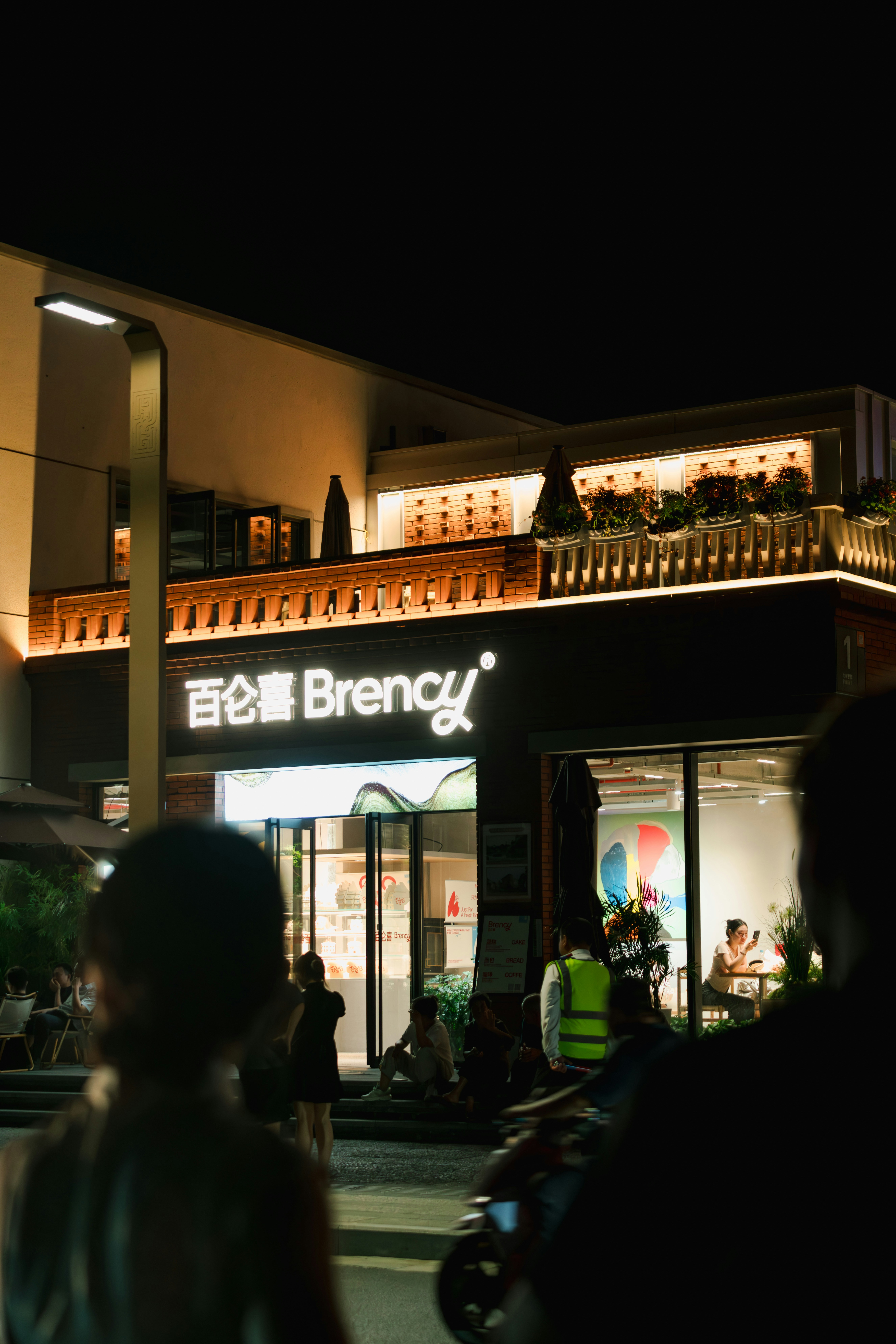 A group of people standing outside of a building at night