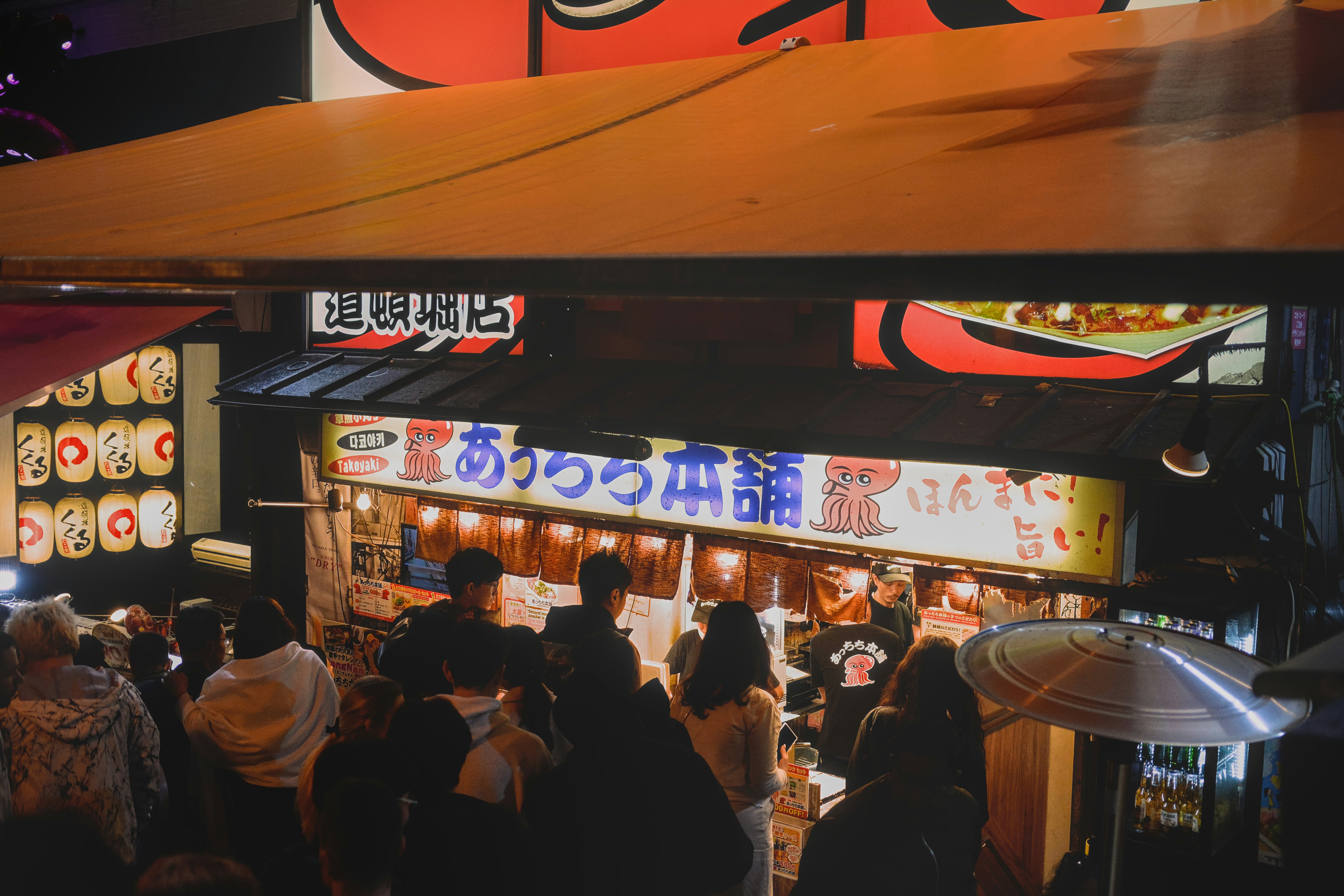 A group of people standing in front of a restaurant