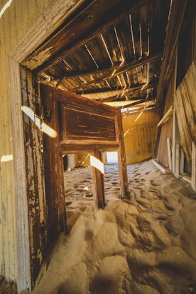 An open door to a room with sand on the floor