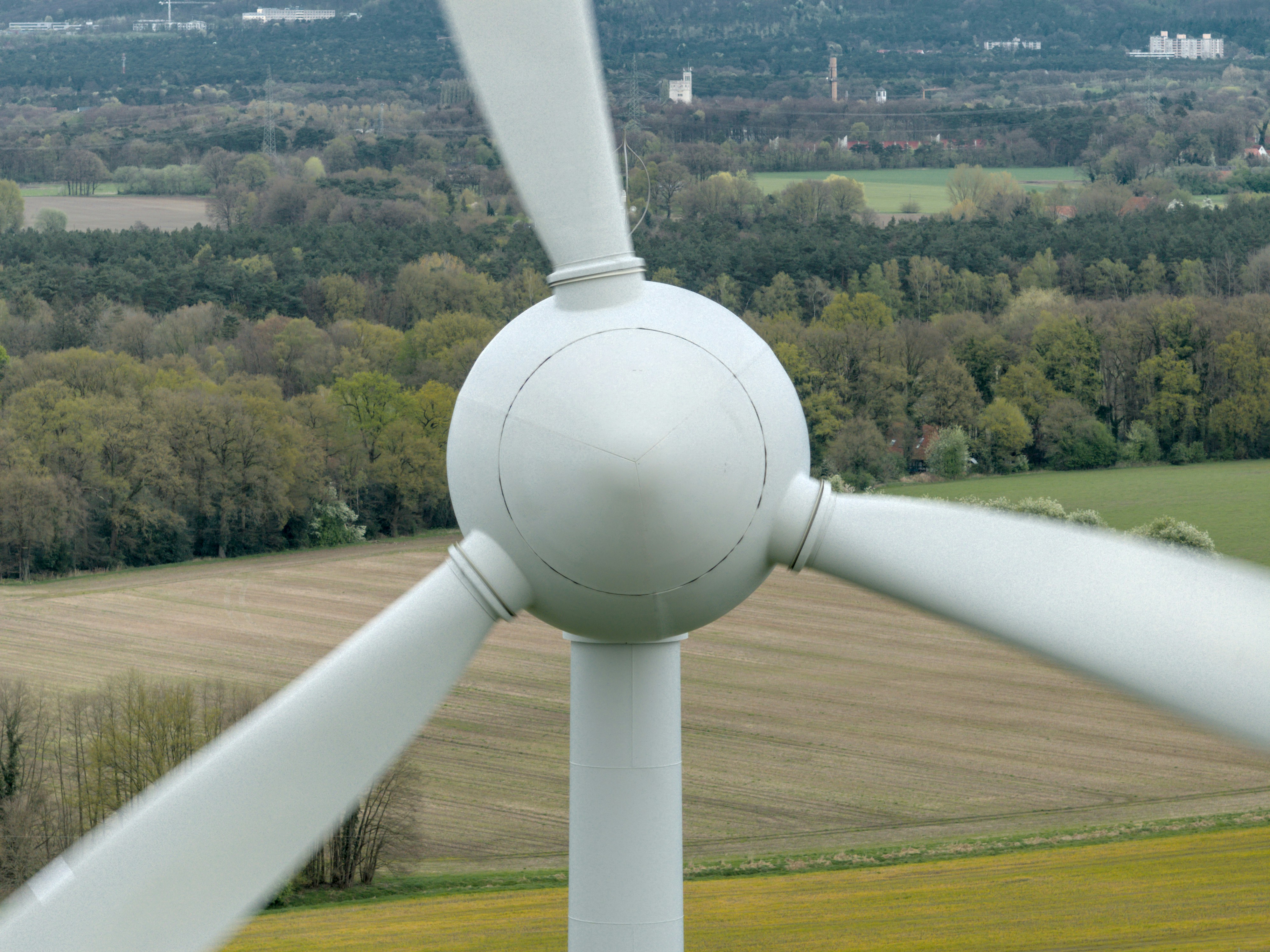 A wind turbine in a field with trees in the background
