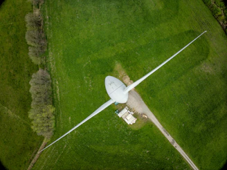 An aerial view of a wind turbine in a green field