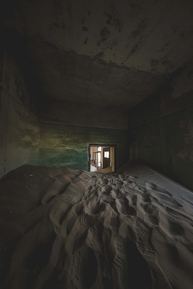 Sand dunes filling a Kolmanskop room through the doorway