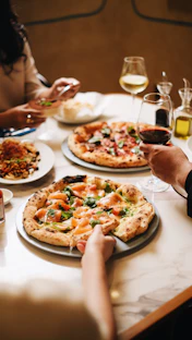 A group of people sitting around a table eating pizza