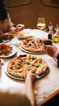A group of people sitting around a table eating pizza