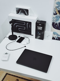 A desk with a laptop and other electronics on it