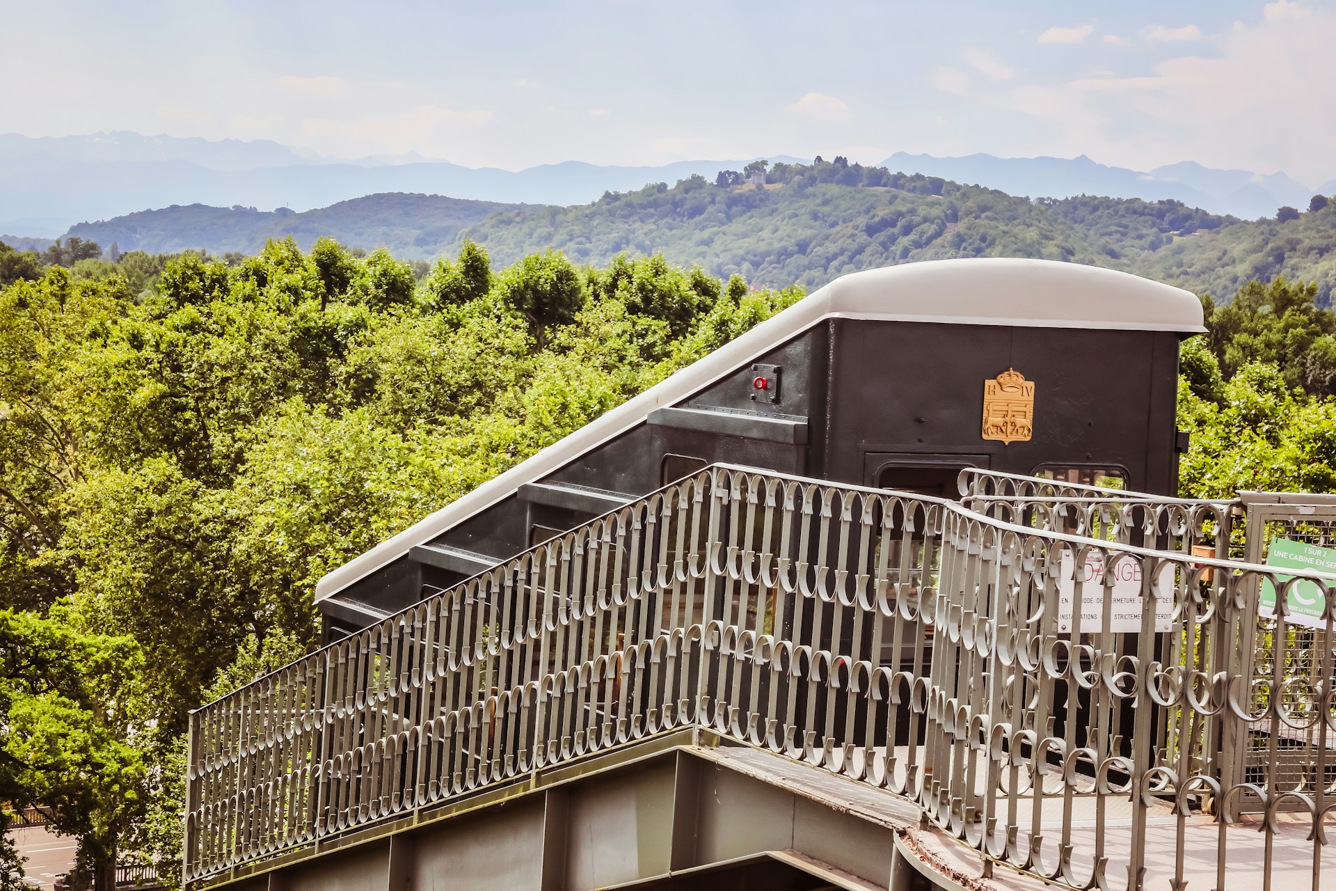 A train traveling over a bridge over a lush green hillside