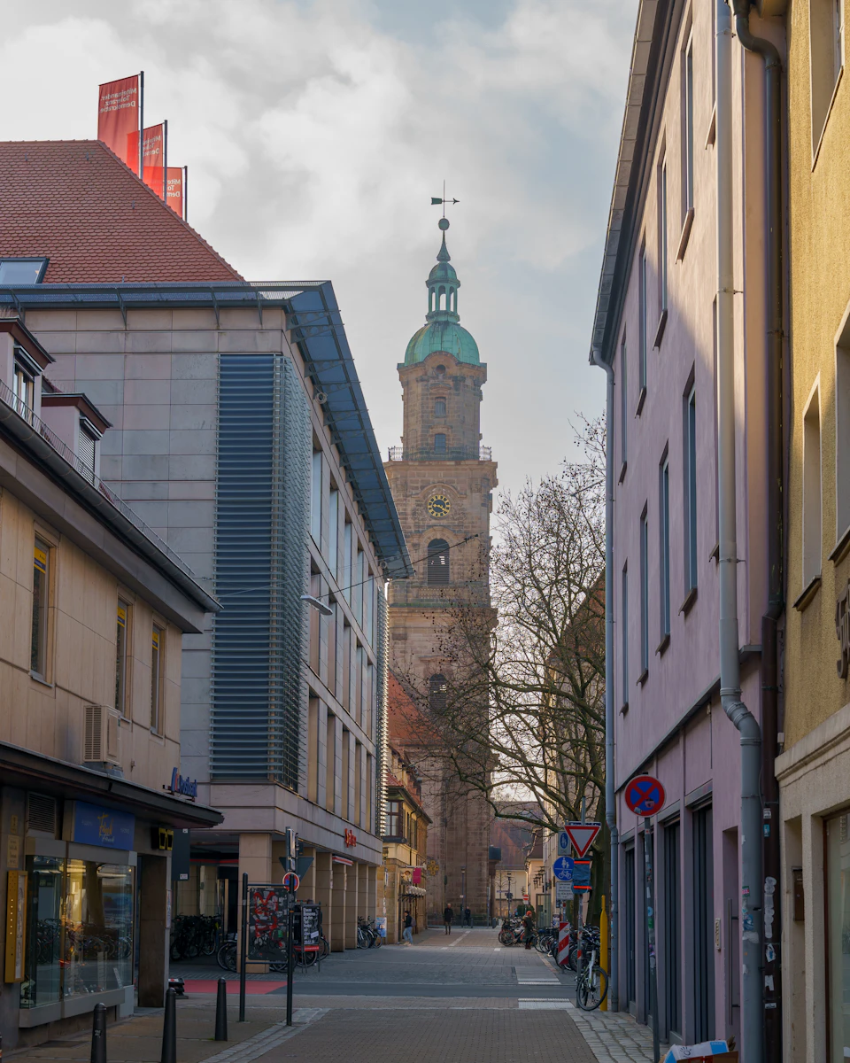 Narrow European street lined with tall brick building and colorful two-story houses nearby