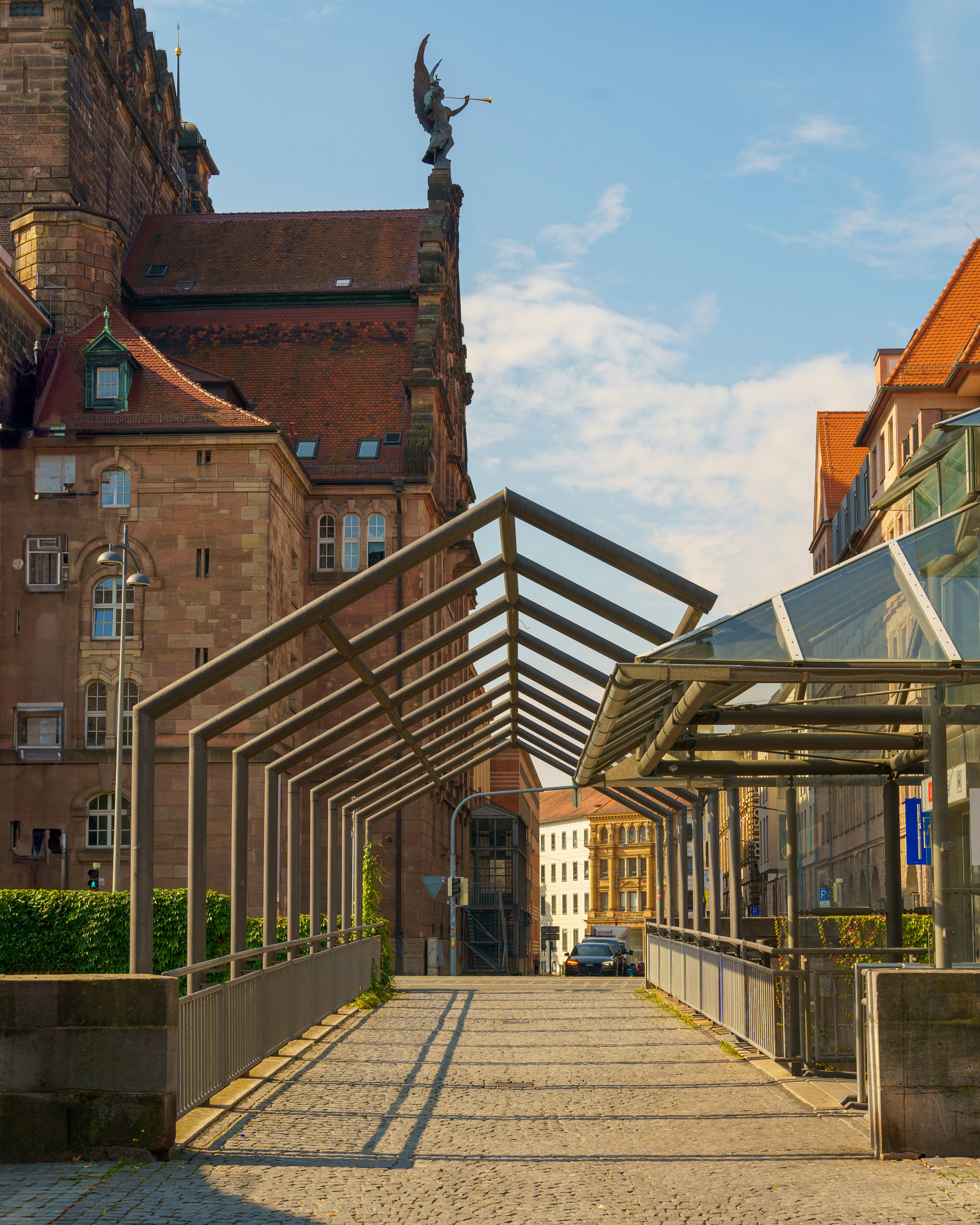 Ein Gang, der zu einem Gebäude mit einem Uhrenturm im Hintergrund führt