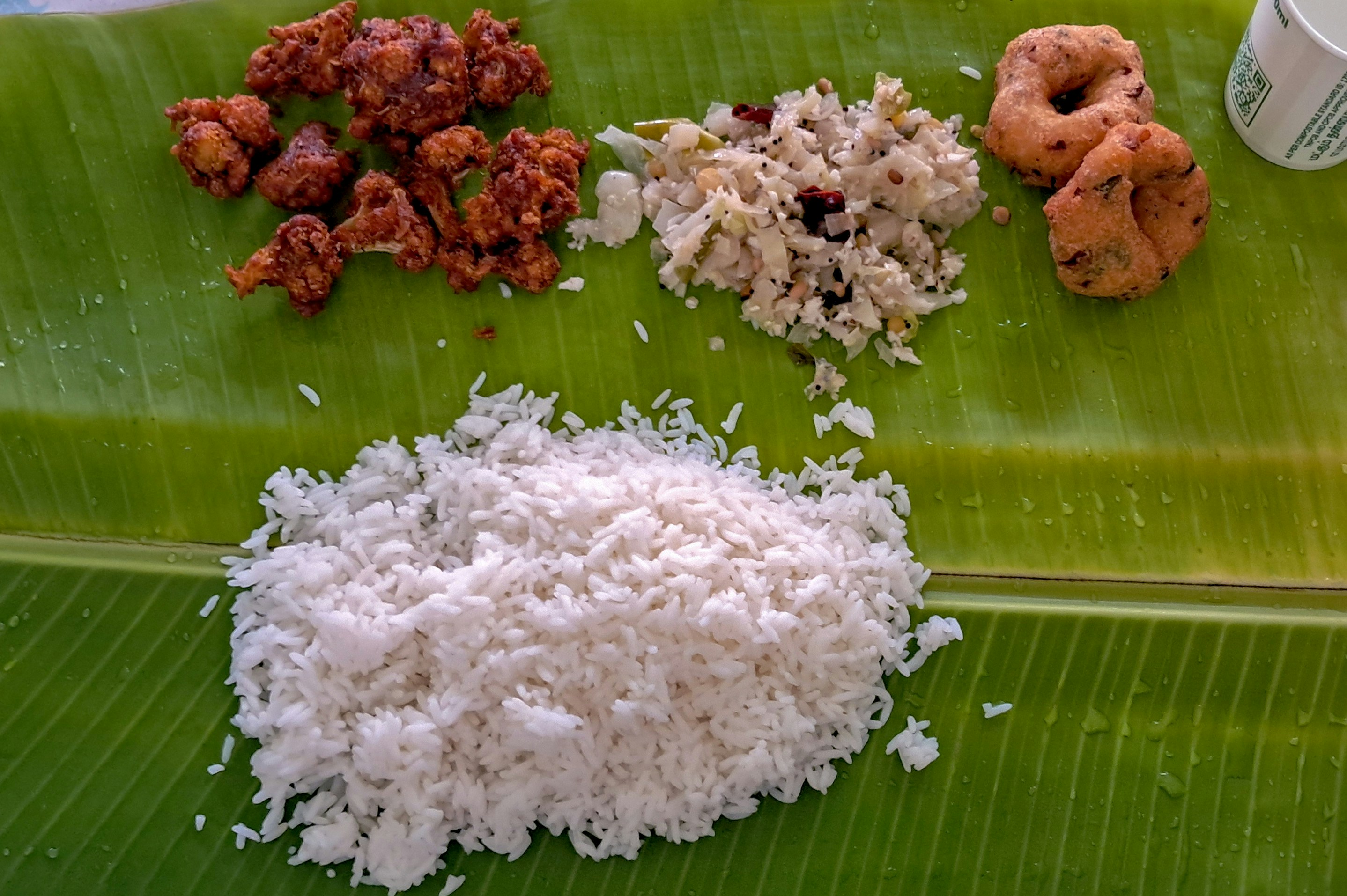 Traditional Karnataka meal spread with ragi mudde, sambar, fresh vegetables and filter coffee on banana leaf