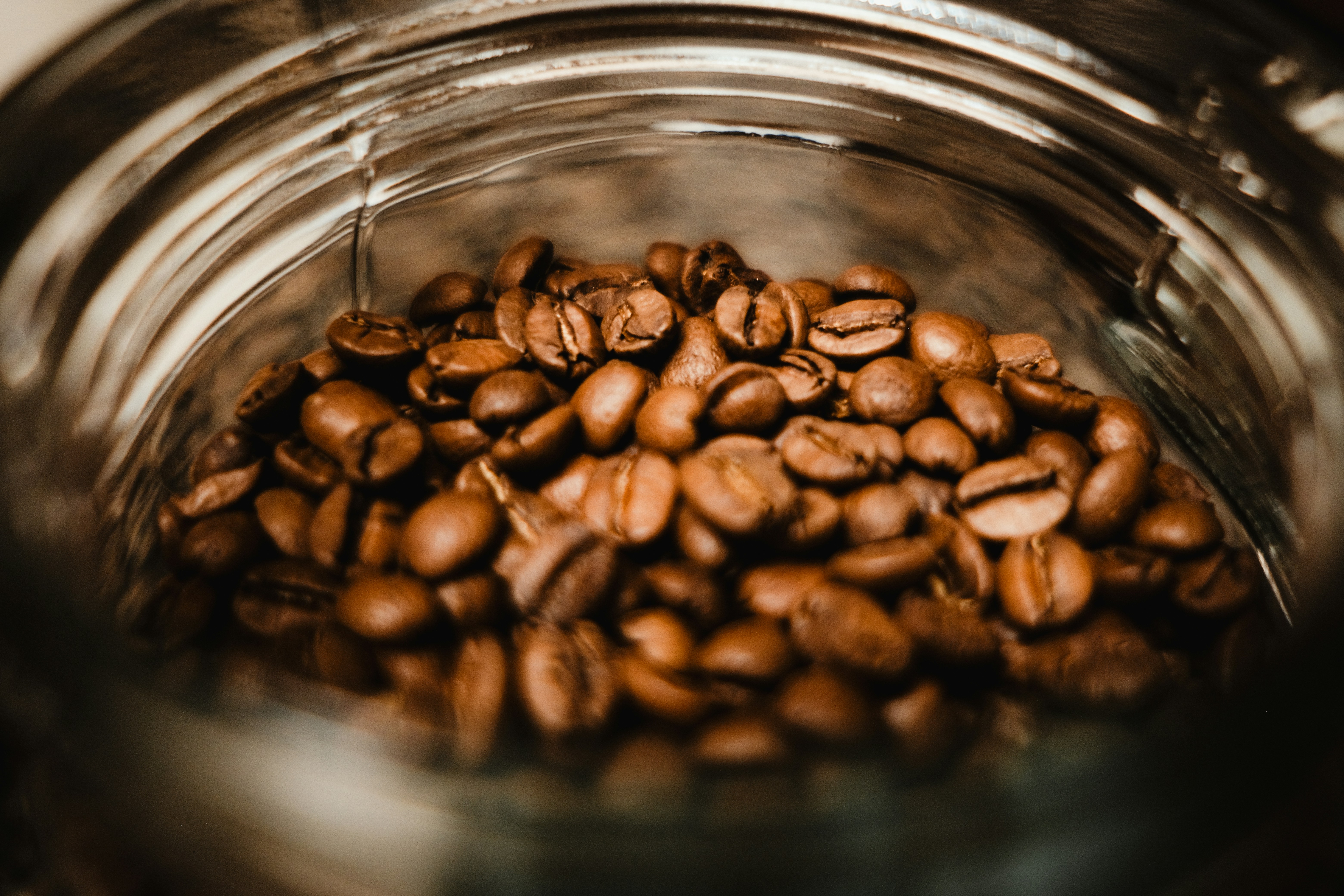 A glass jar filled with lots of coffee beans