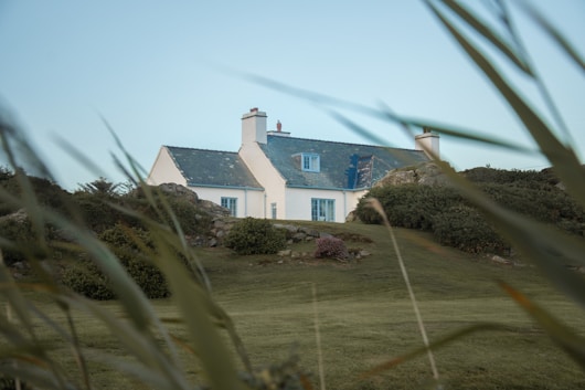 A white house sitting on top of a lush green field