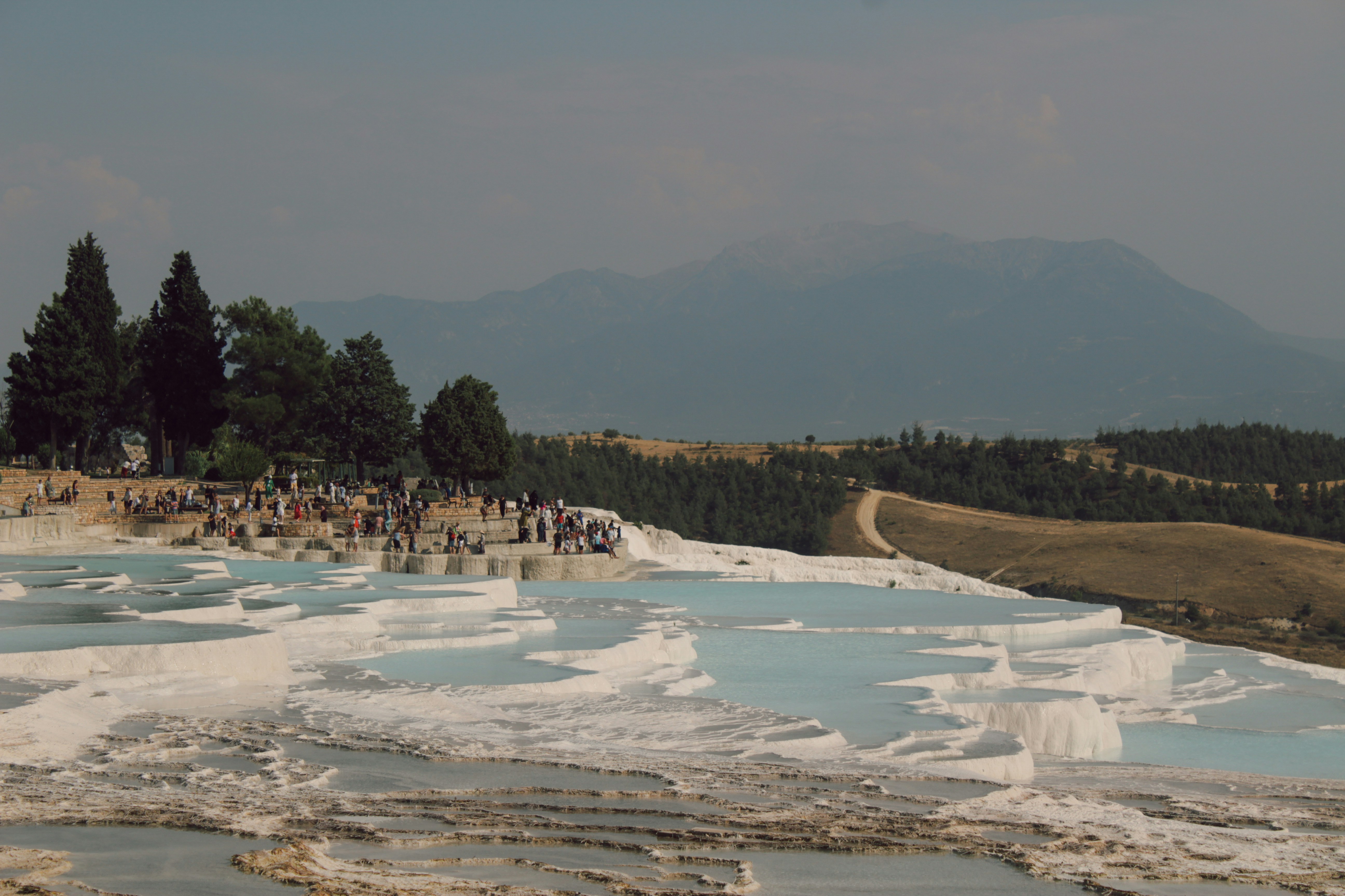 A group of people standing on a beach next to a body of water