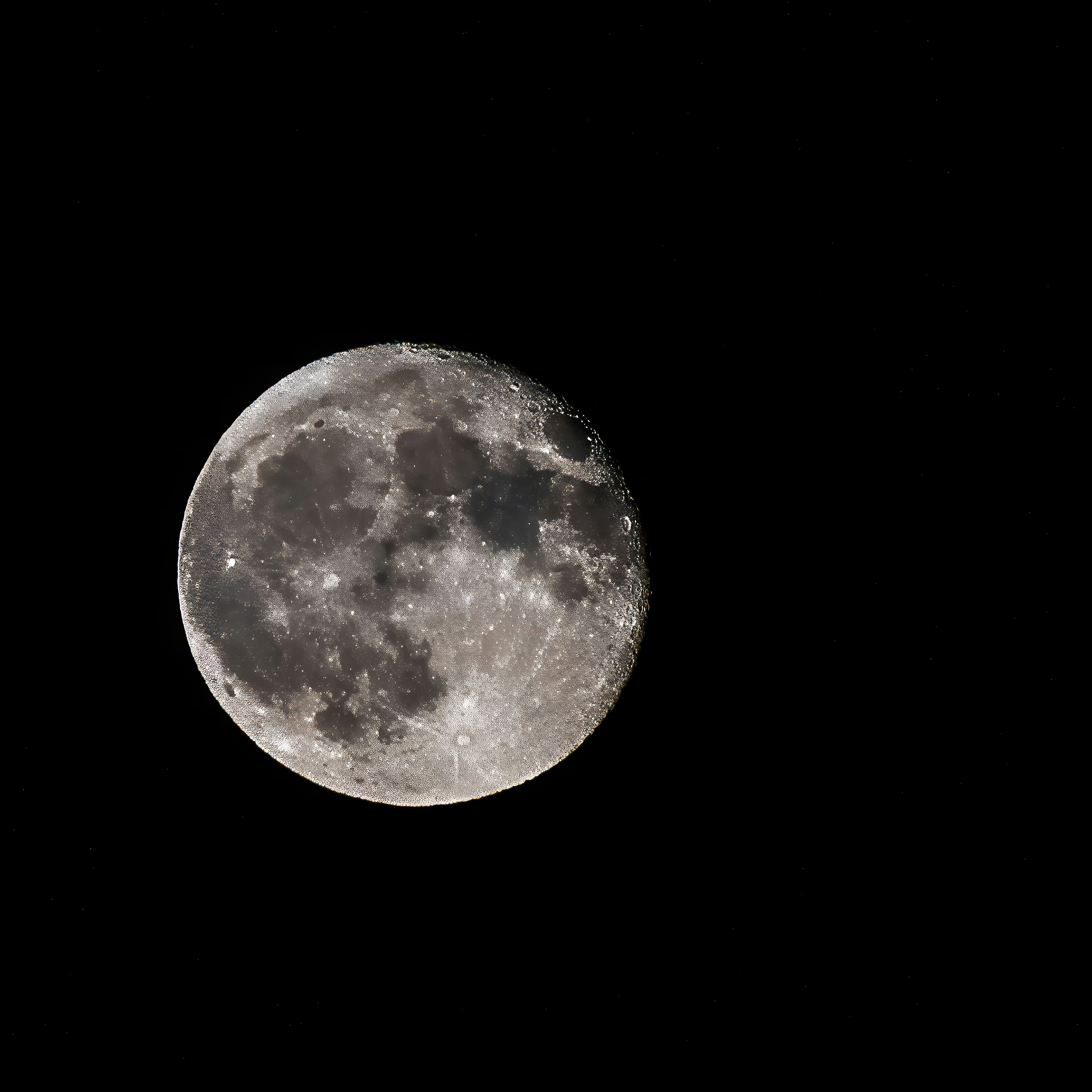A full moon is seen in the dark sky